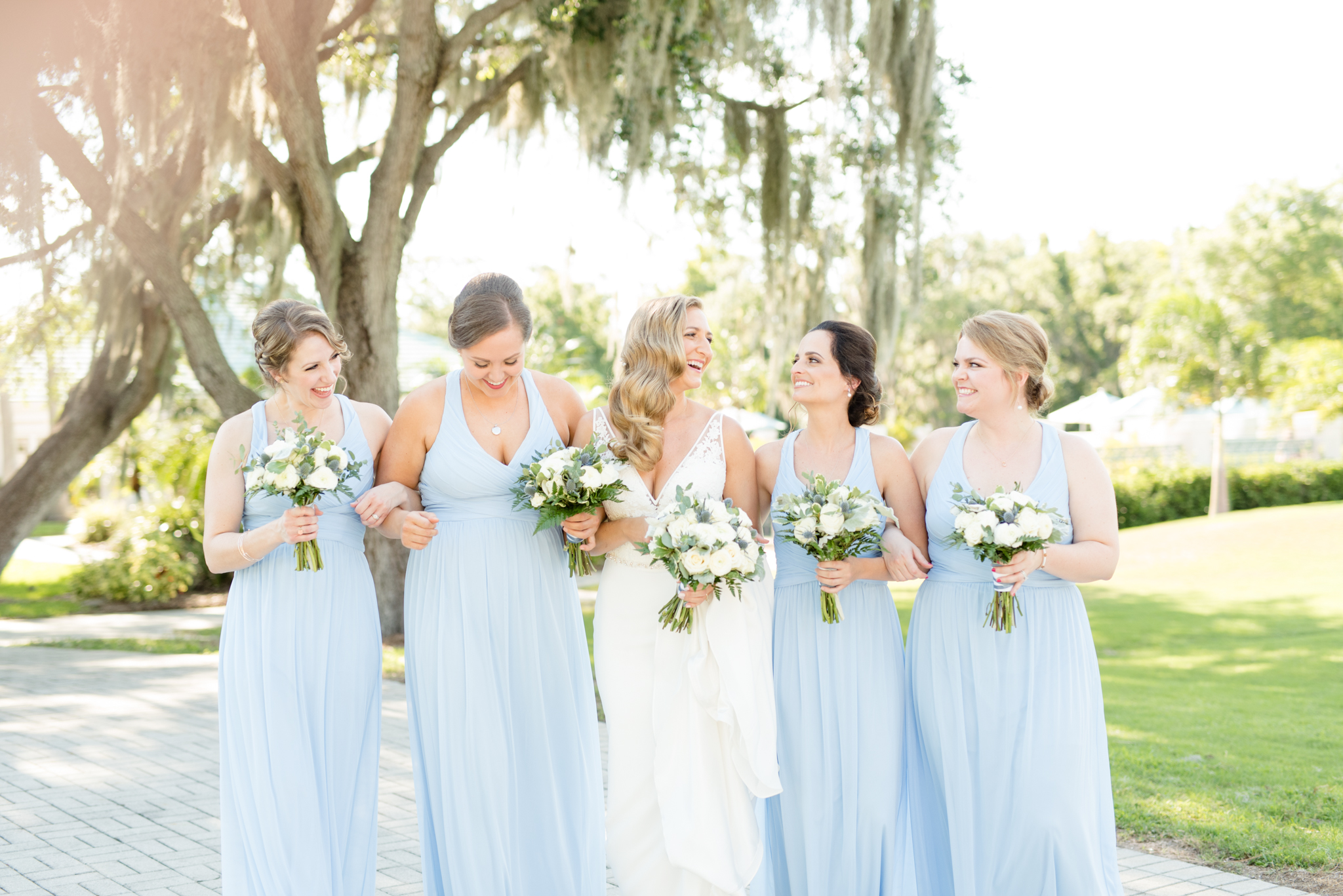 Bride and bridesmaid's laugh as they walk.