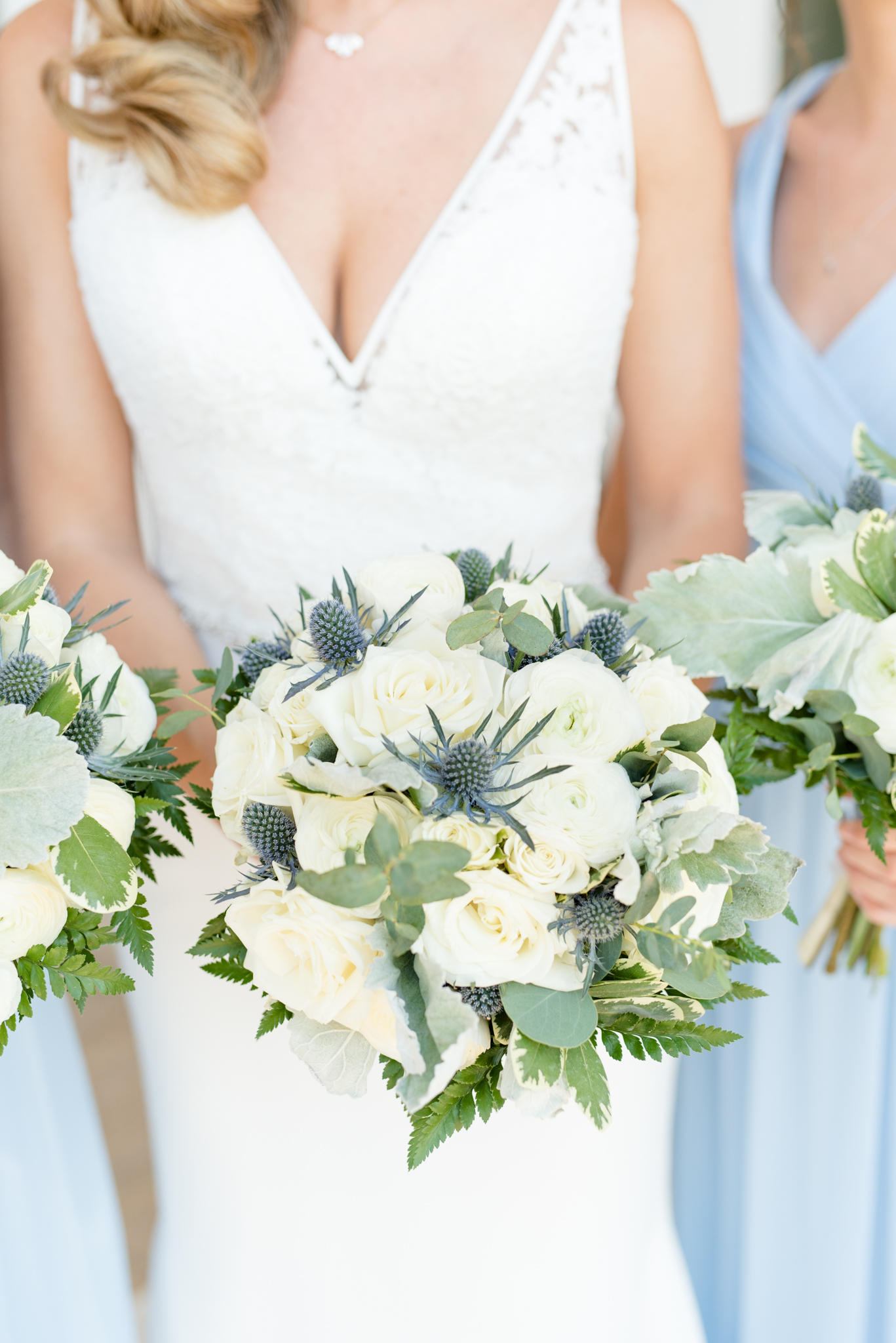 Bridal party holds Cream and blue Wedding flowers
