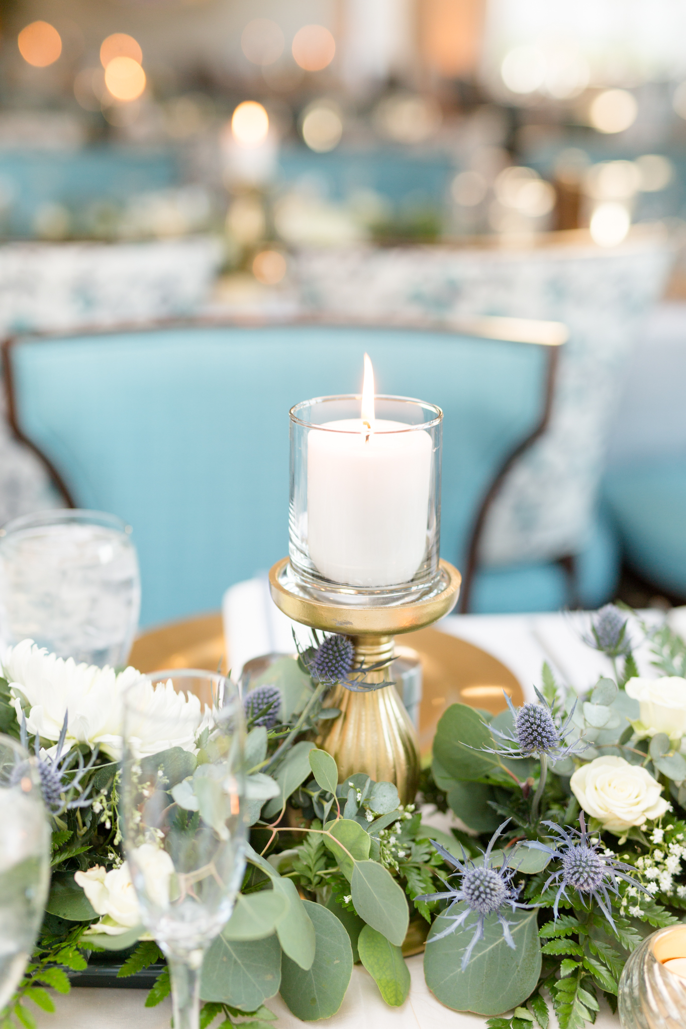 Candle burns on wedding reception table.