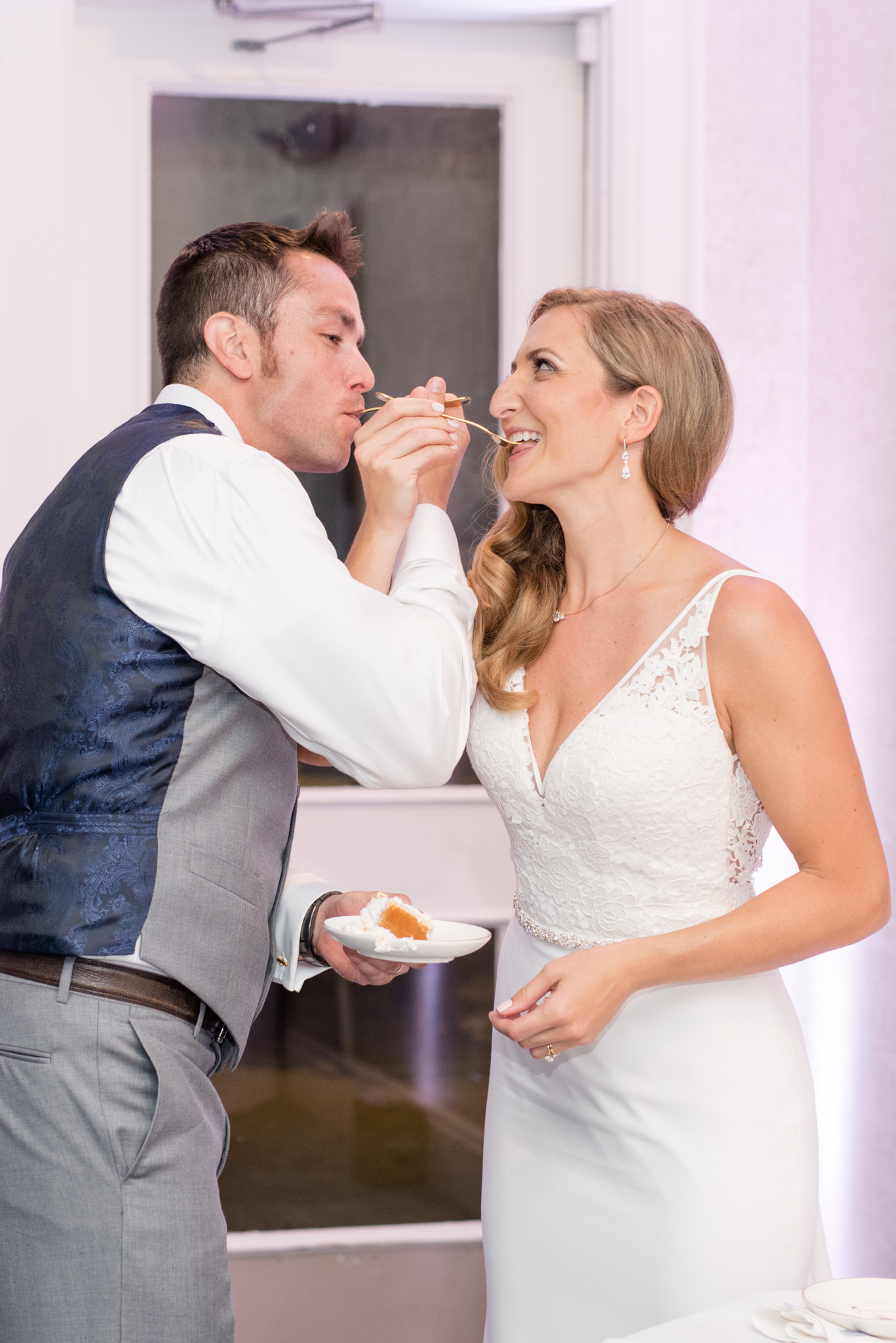 Bride and groom eat cake together.