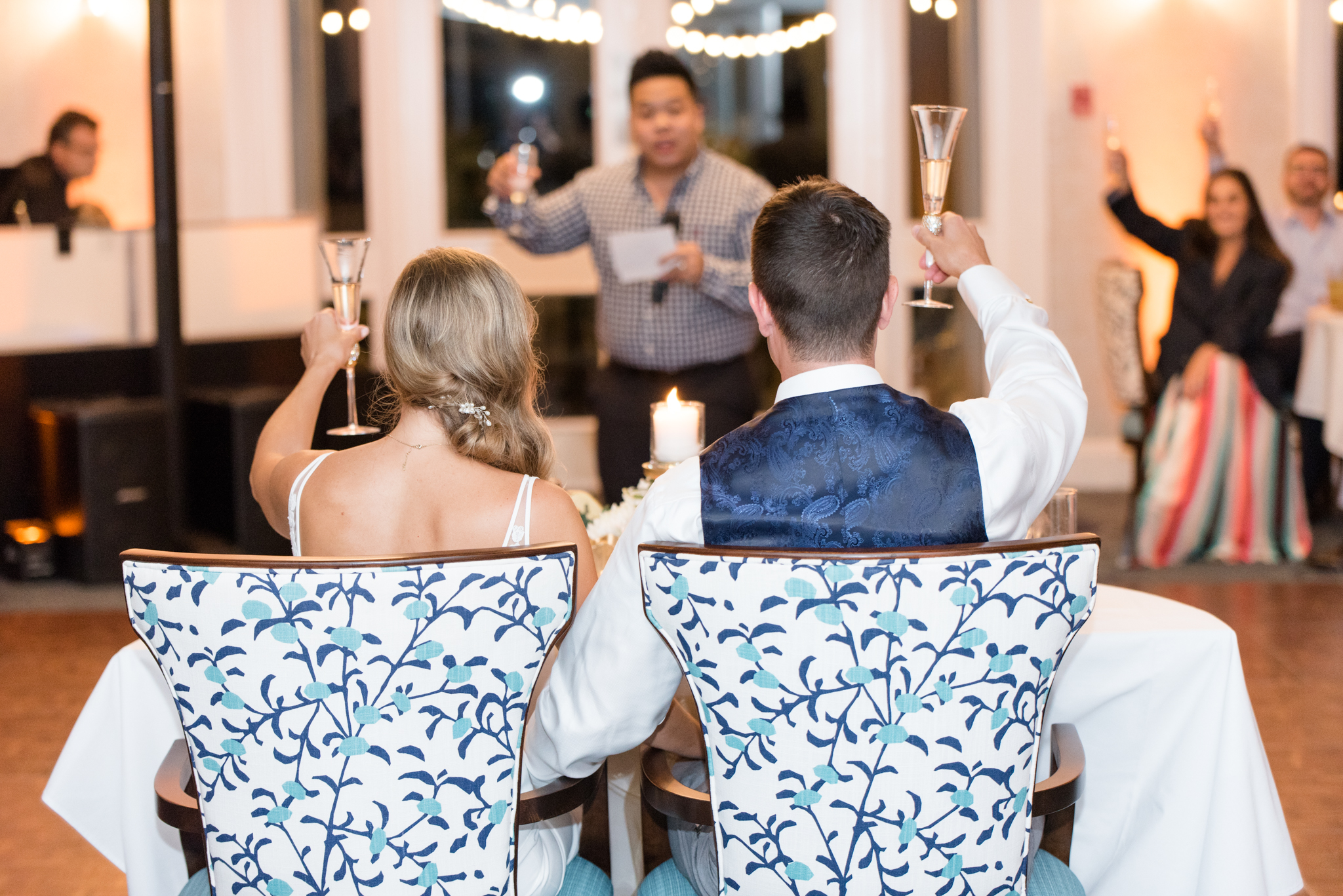 Bride and groom raise glasses during toast.