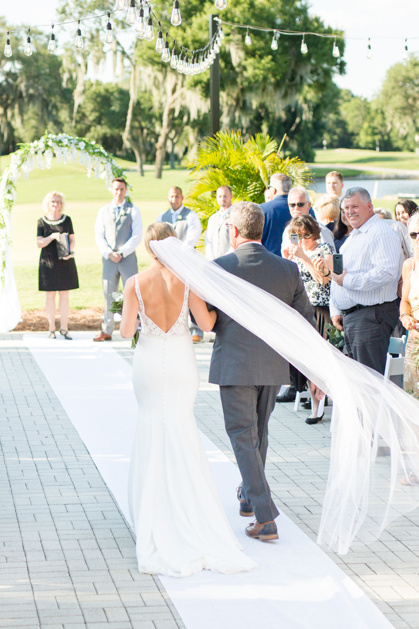 Bride and father walk down aisle.