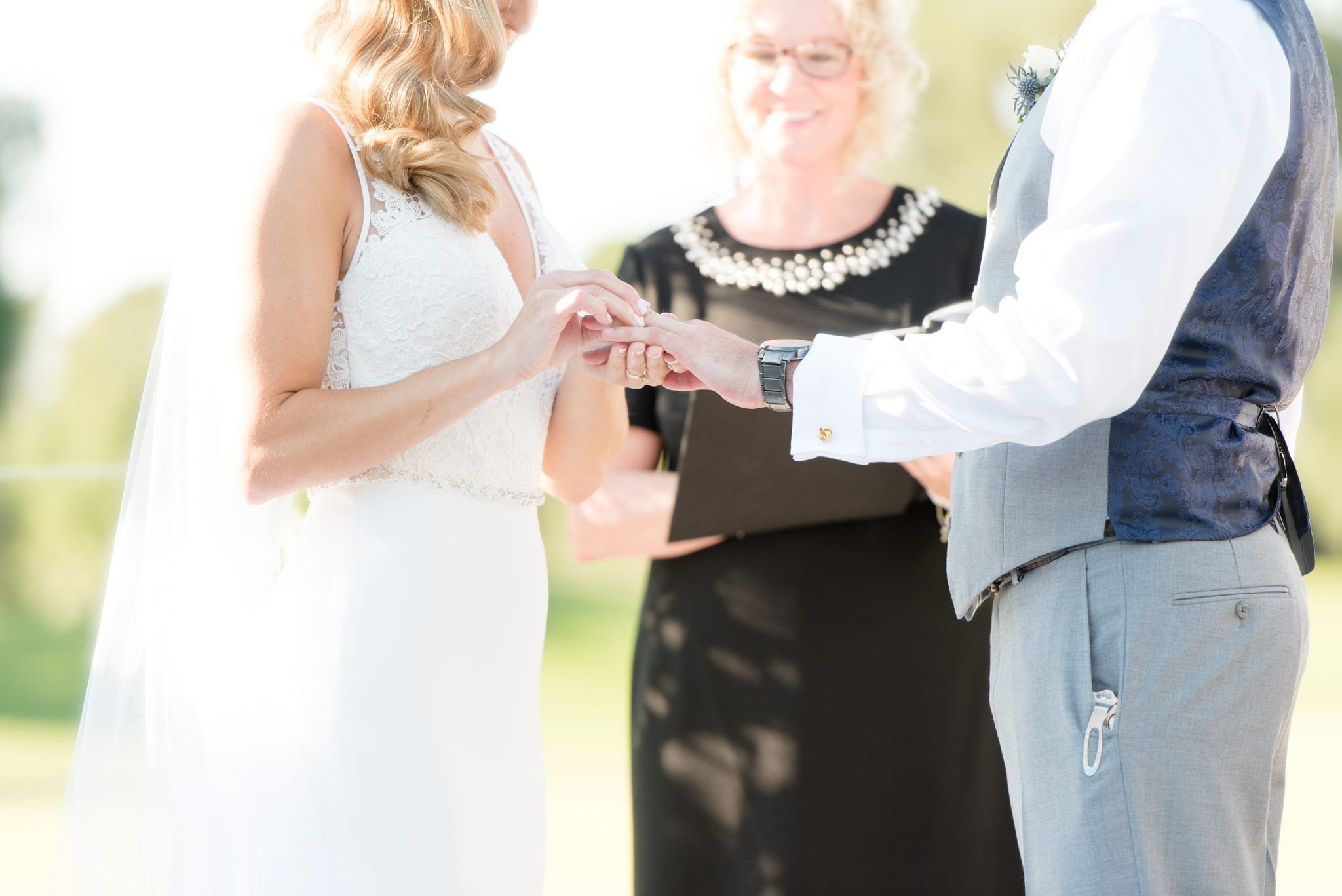 Bride places ring on groom.