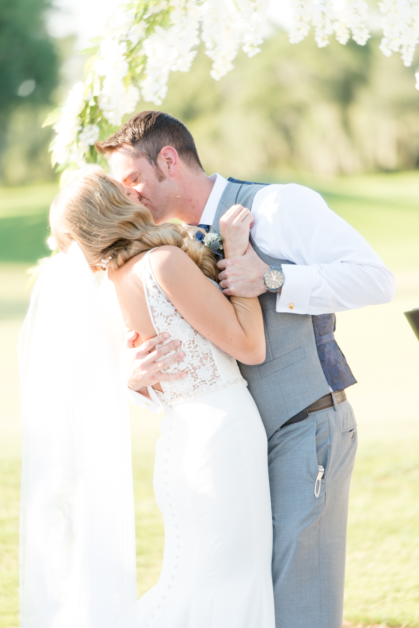 Bride and groom kiss during May wedding ceremony.