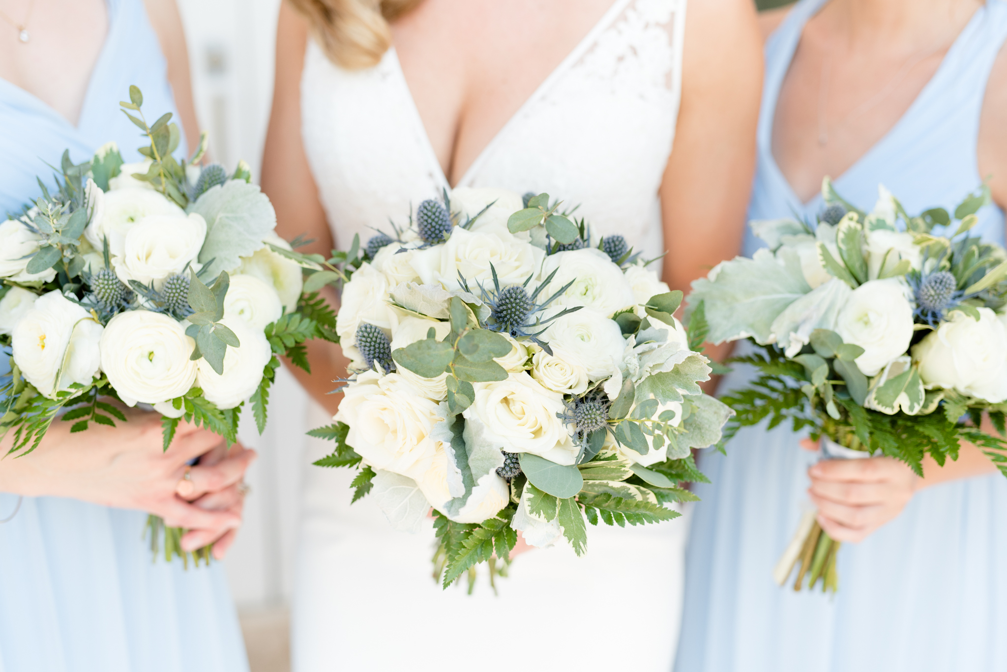 Bridal party holds cream and blue flowers.