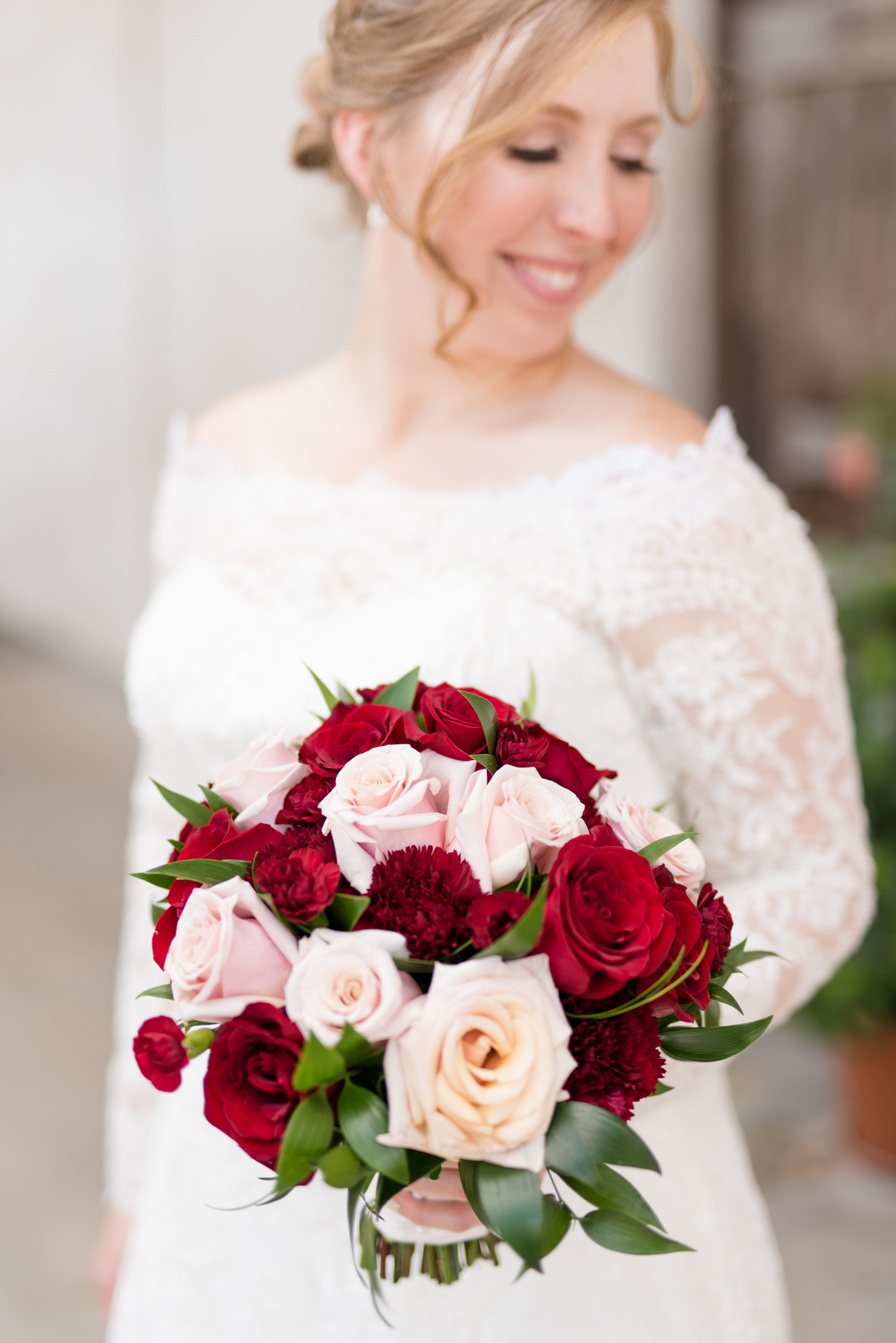 Bride holds flowers and smiles.