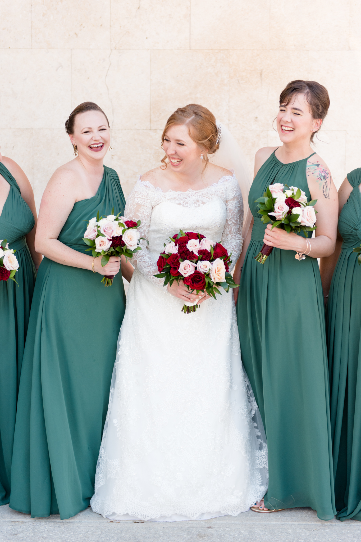 Bride and bridesmaids laugh together.