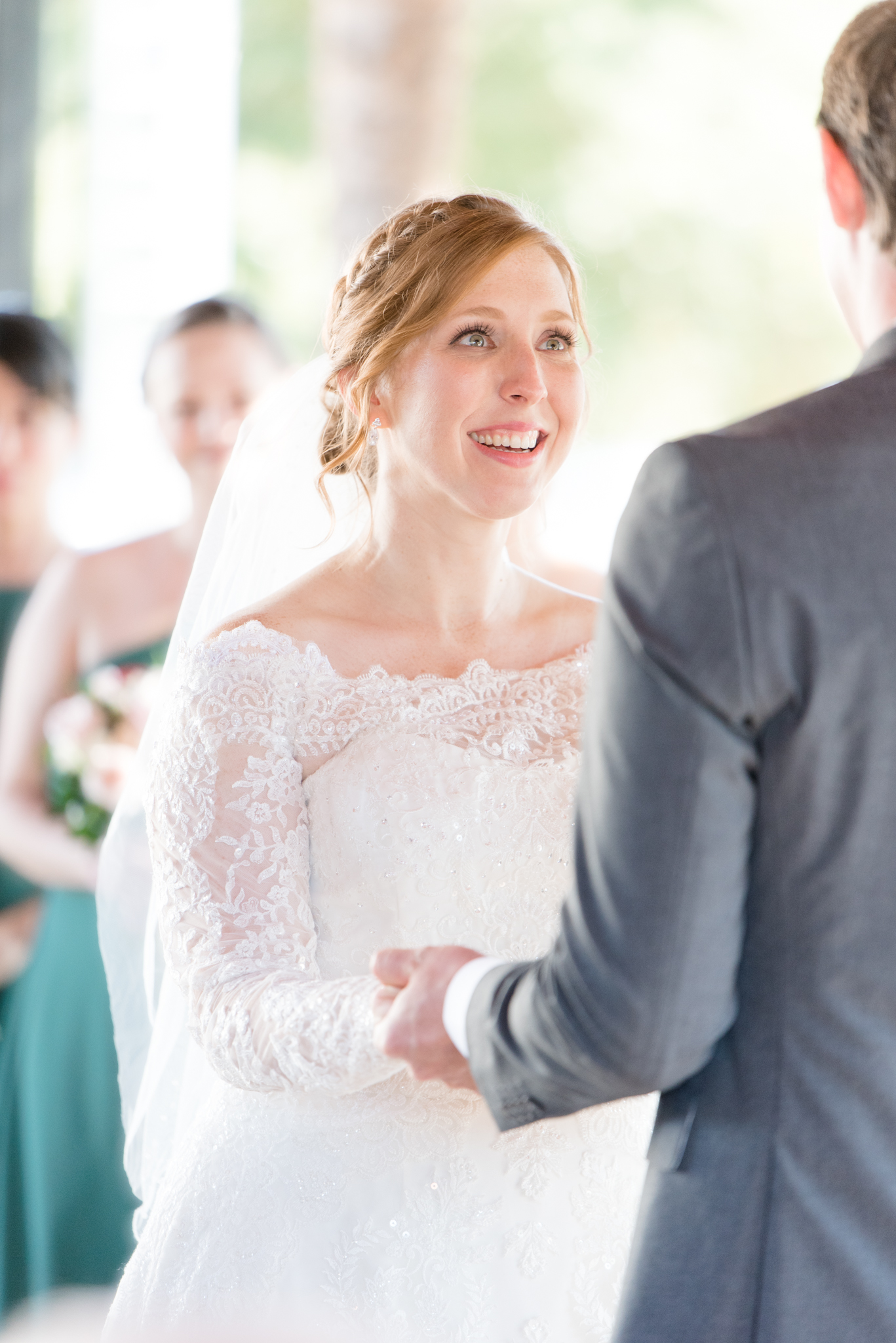 Bride smiles at groom during wedding ceremony.