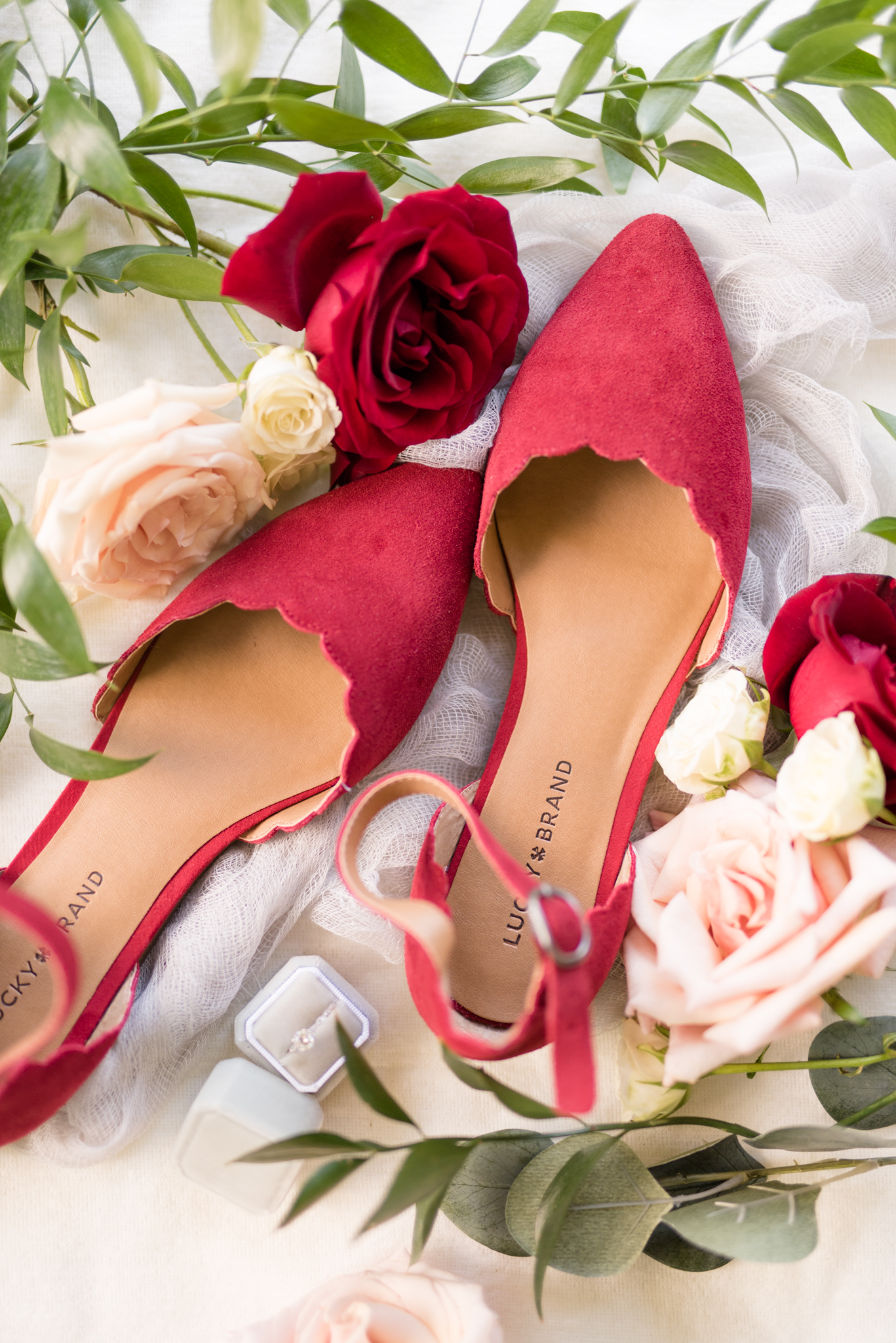 Bridal shoes and details sit among flowers.