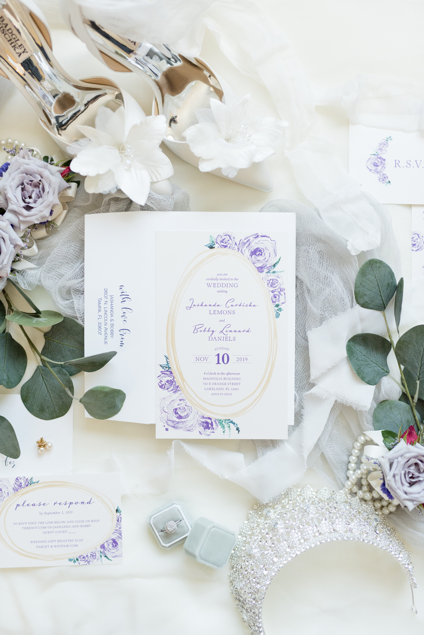Wedding invitation suite sits with bridal details.