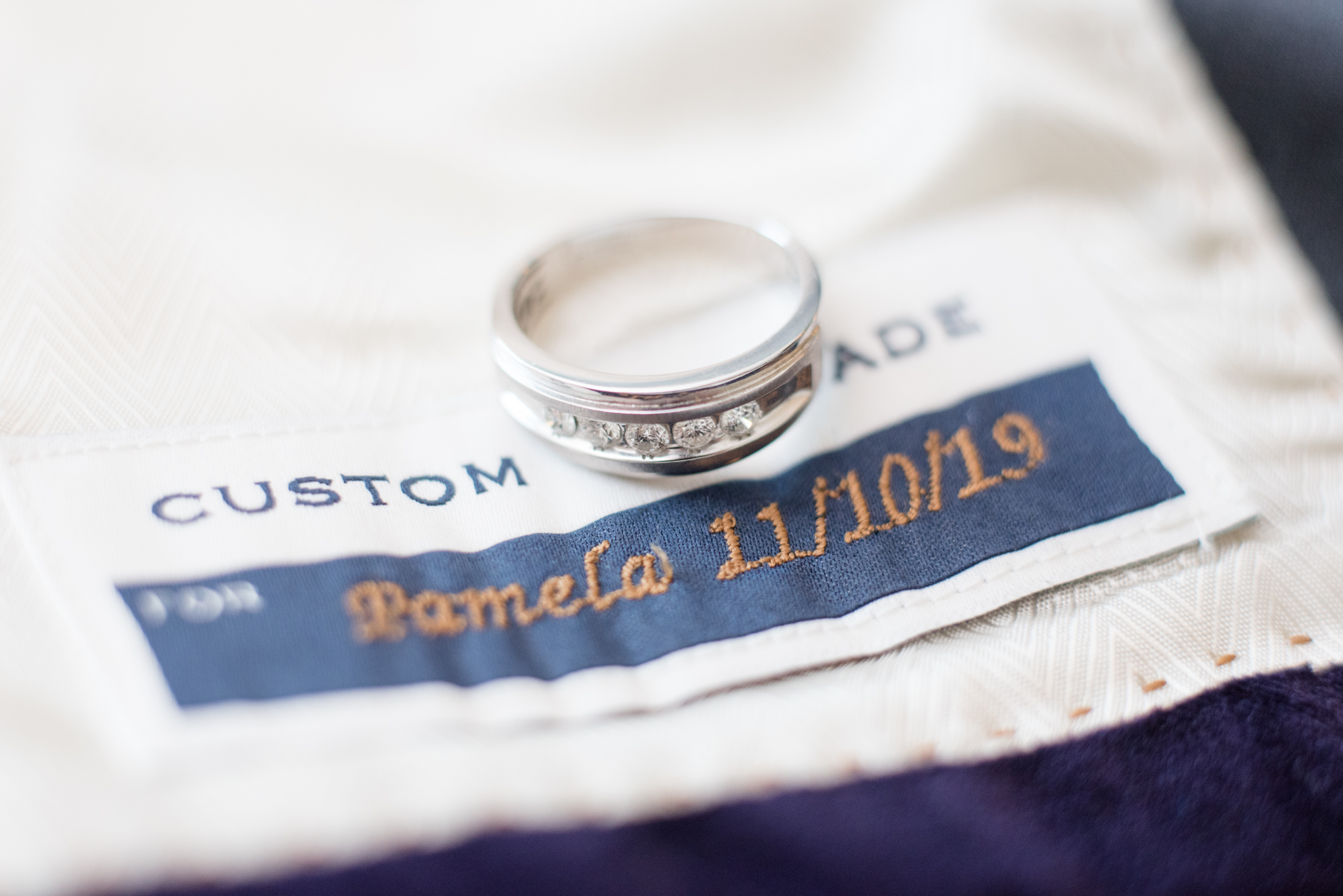 Groom's wedding ring sits with custom suit.