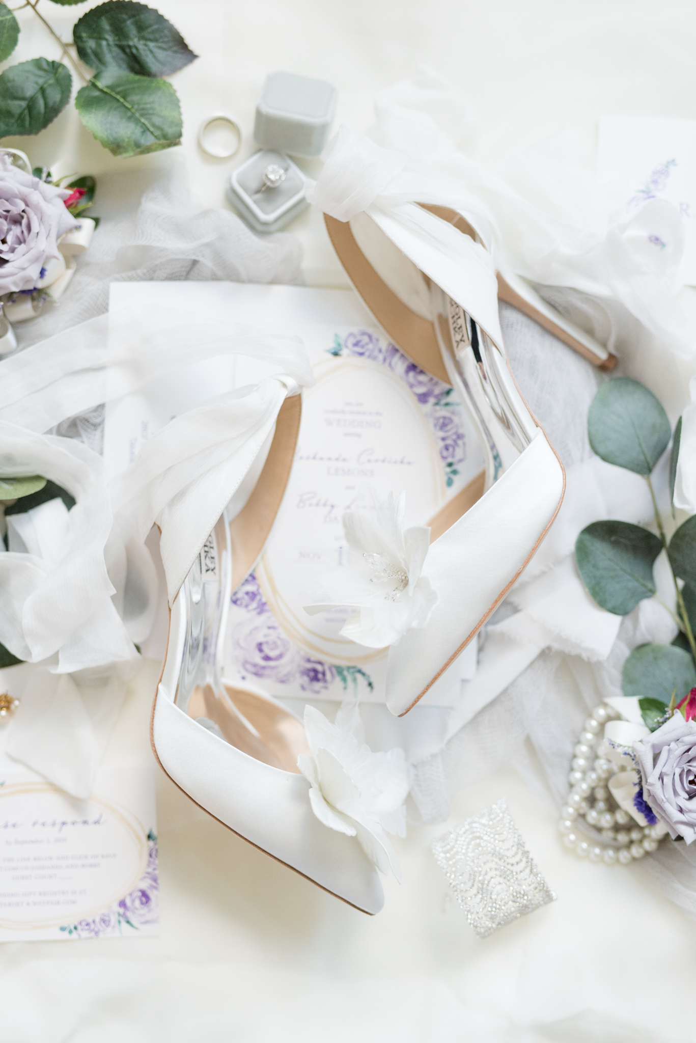 Brides wedding shoes sit on wedding invitation.