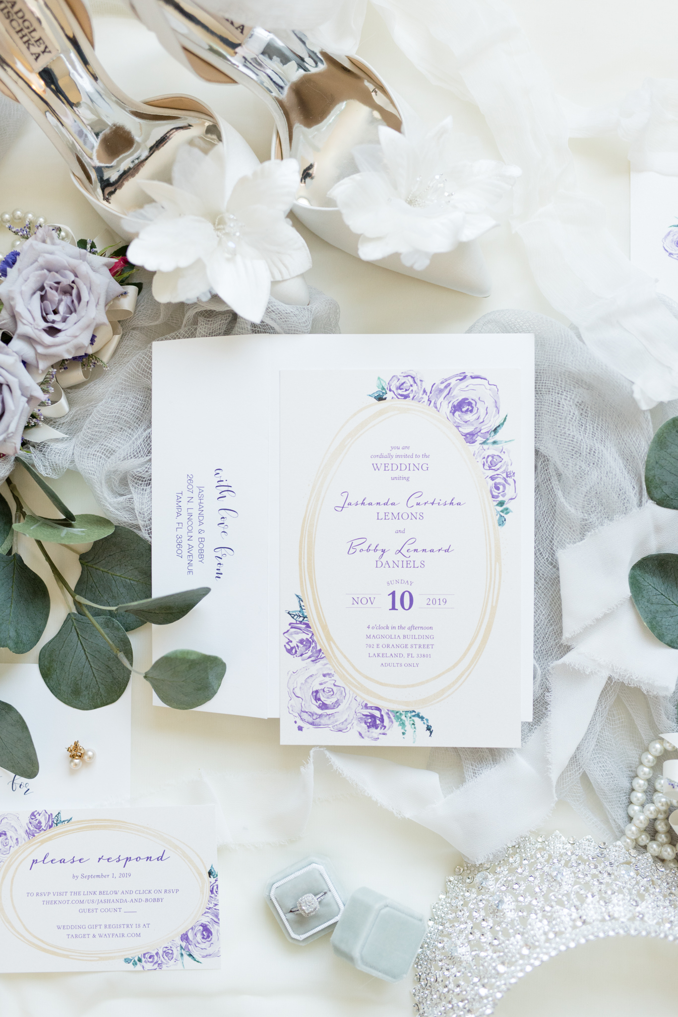 Wedding invitation sits with bridal details.