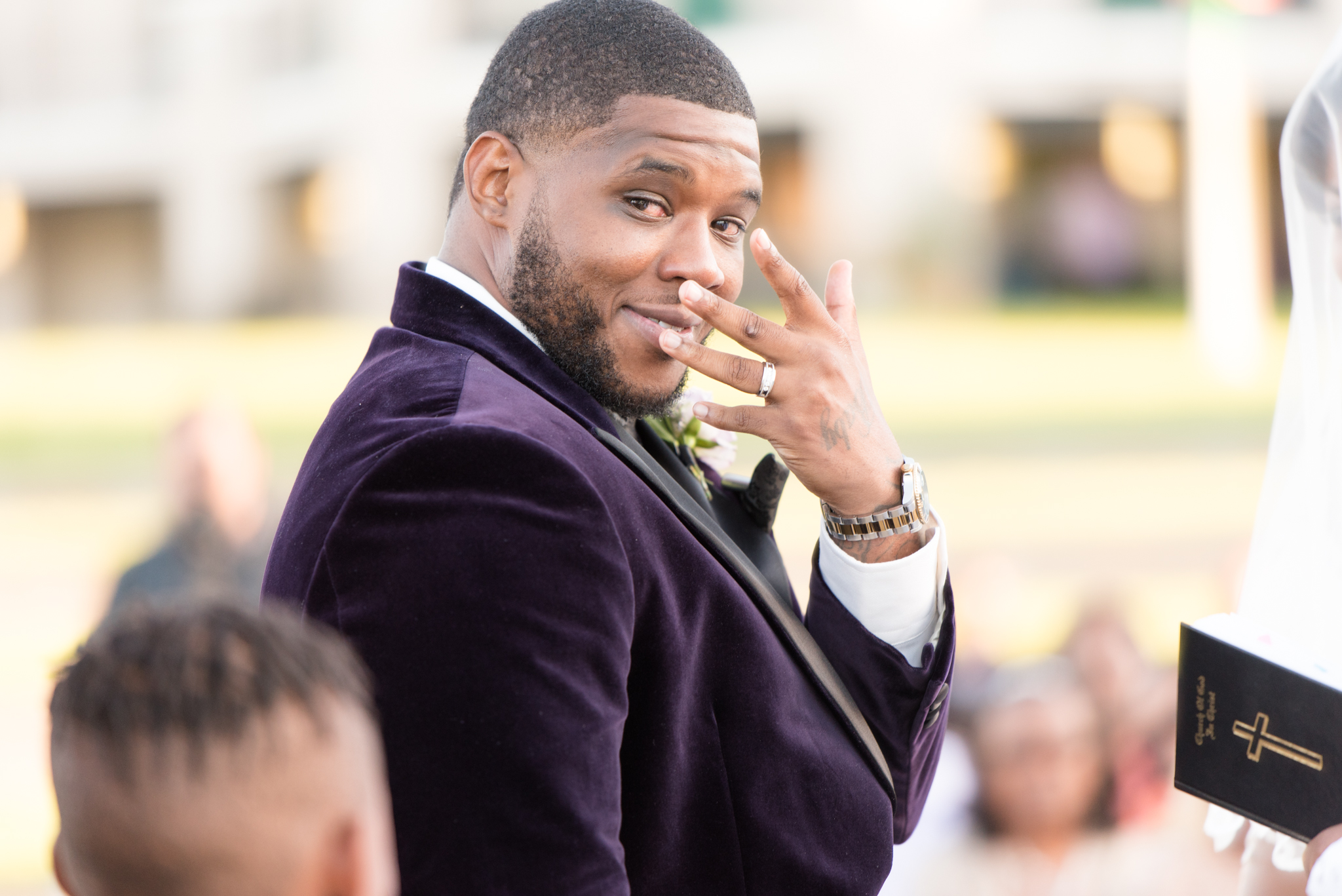 Groom shows off wedding ring during ceremony.