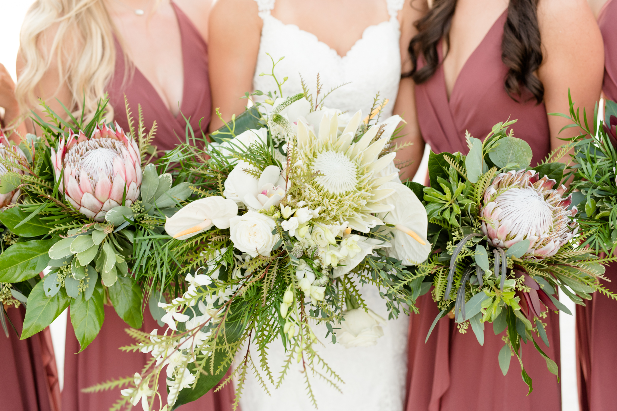Bridal party holds tropical bouquets.