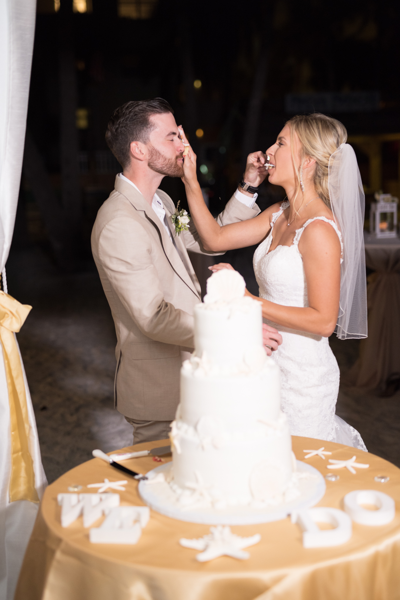 Bride shoves cake in groom's face.