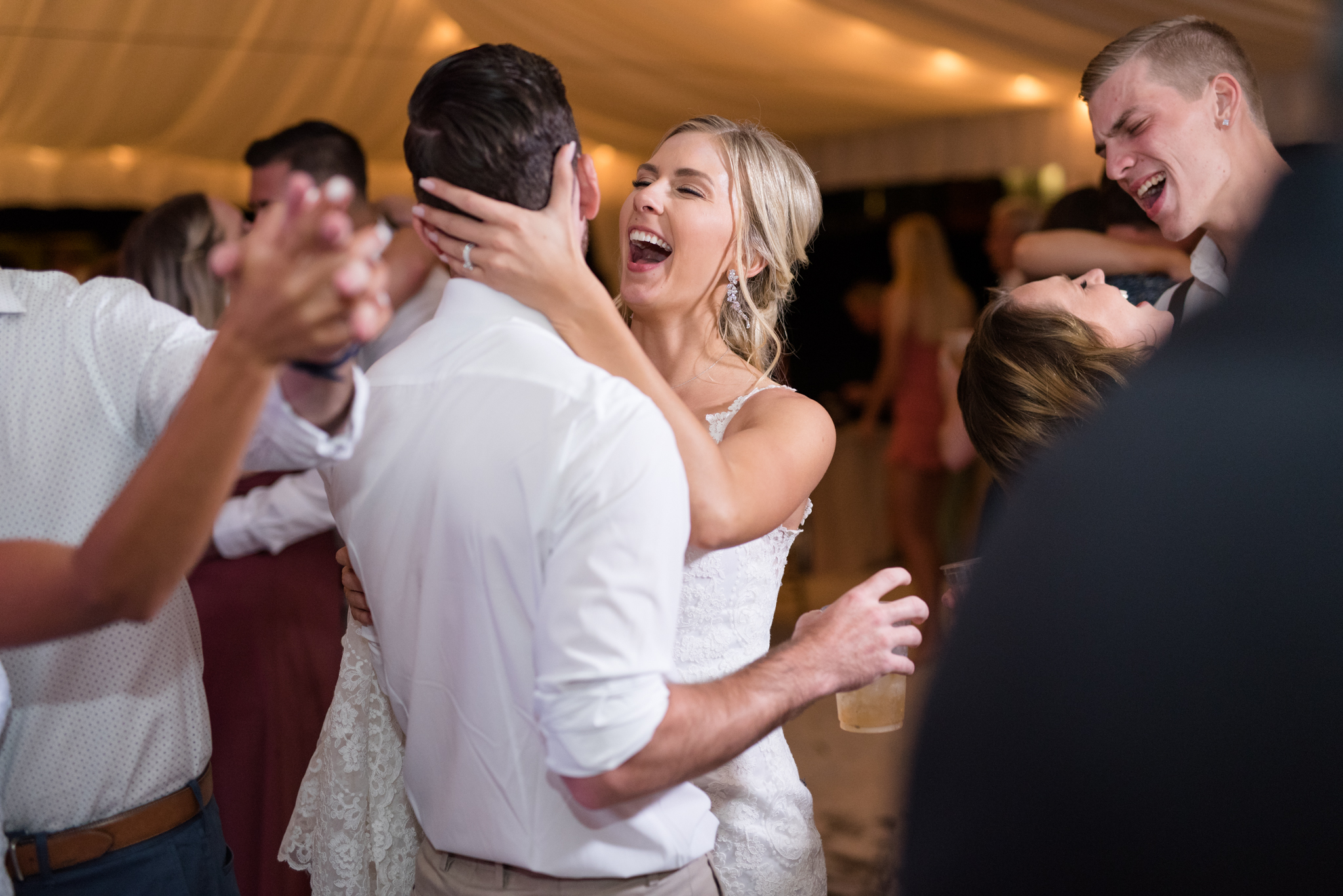 Brice and groom laugh and dance together.