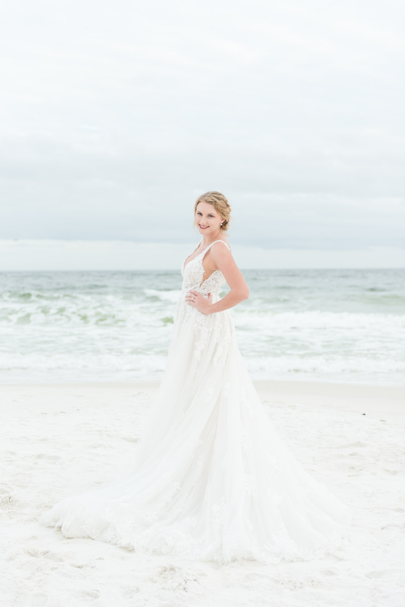 Bride looks over shoulder on beach