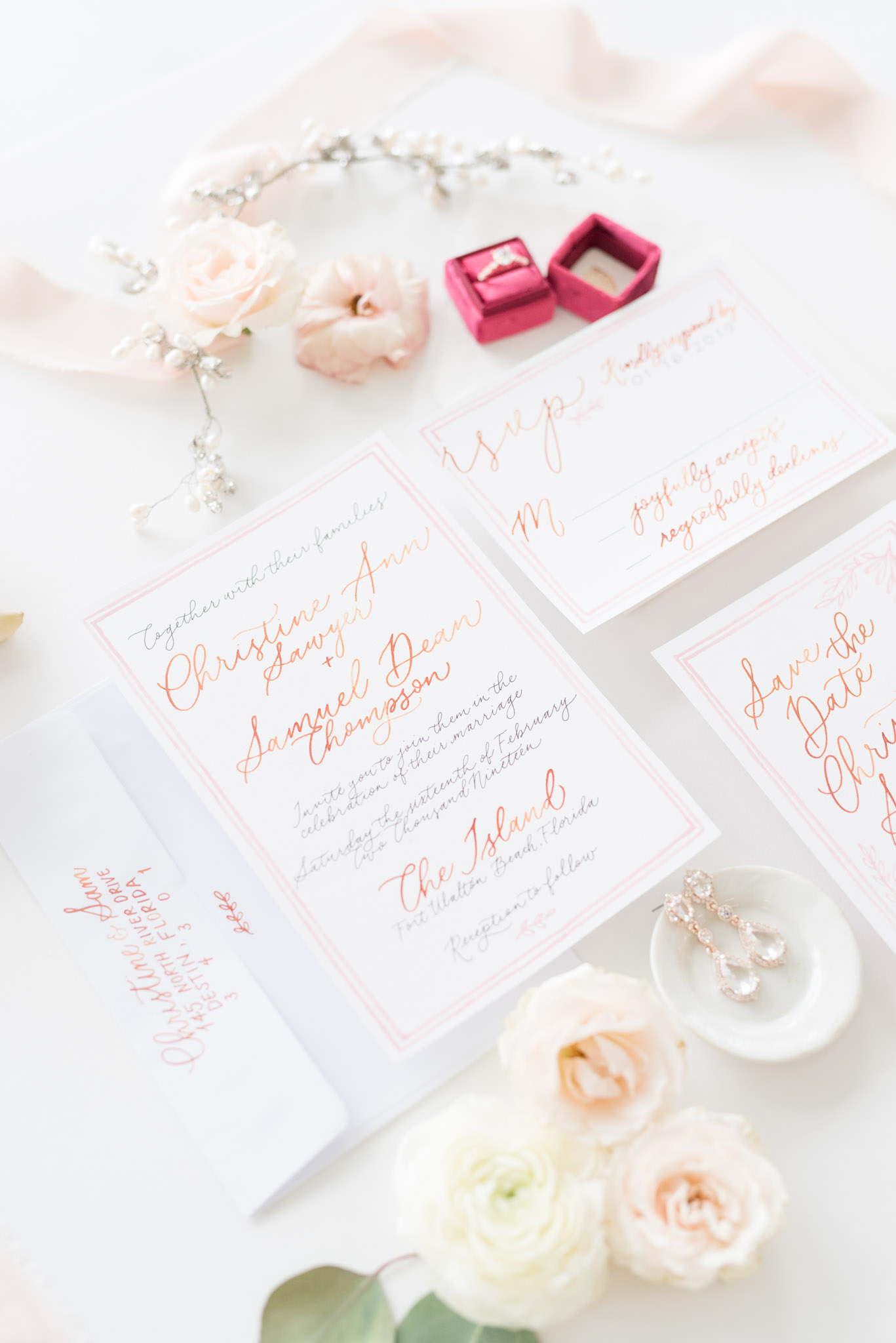Blush and white wedding invitations and ring.