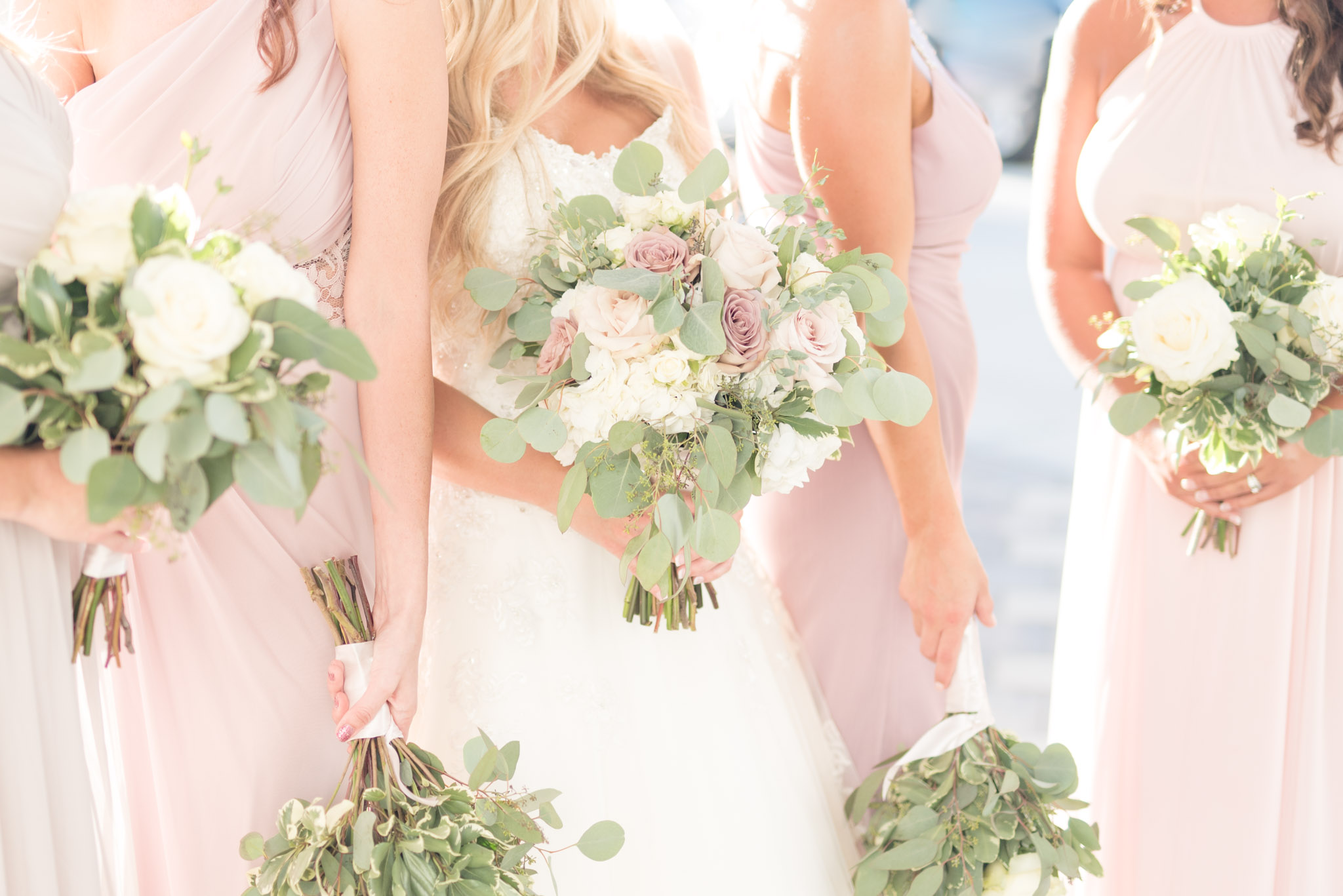 Bride and bridesmaids hold flowers.