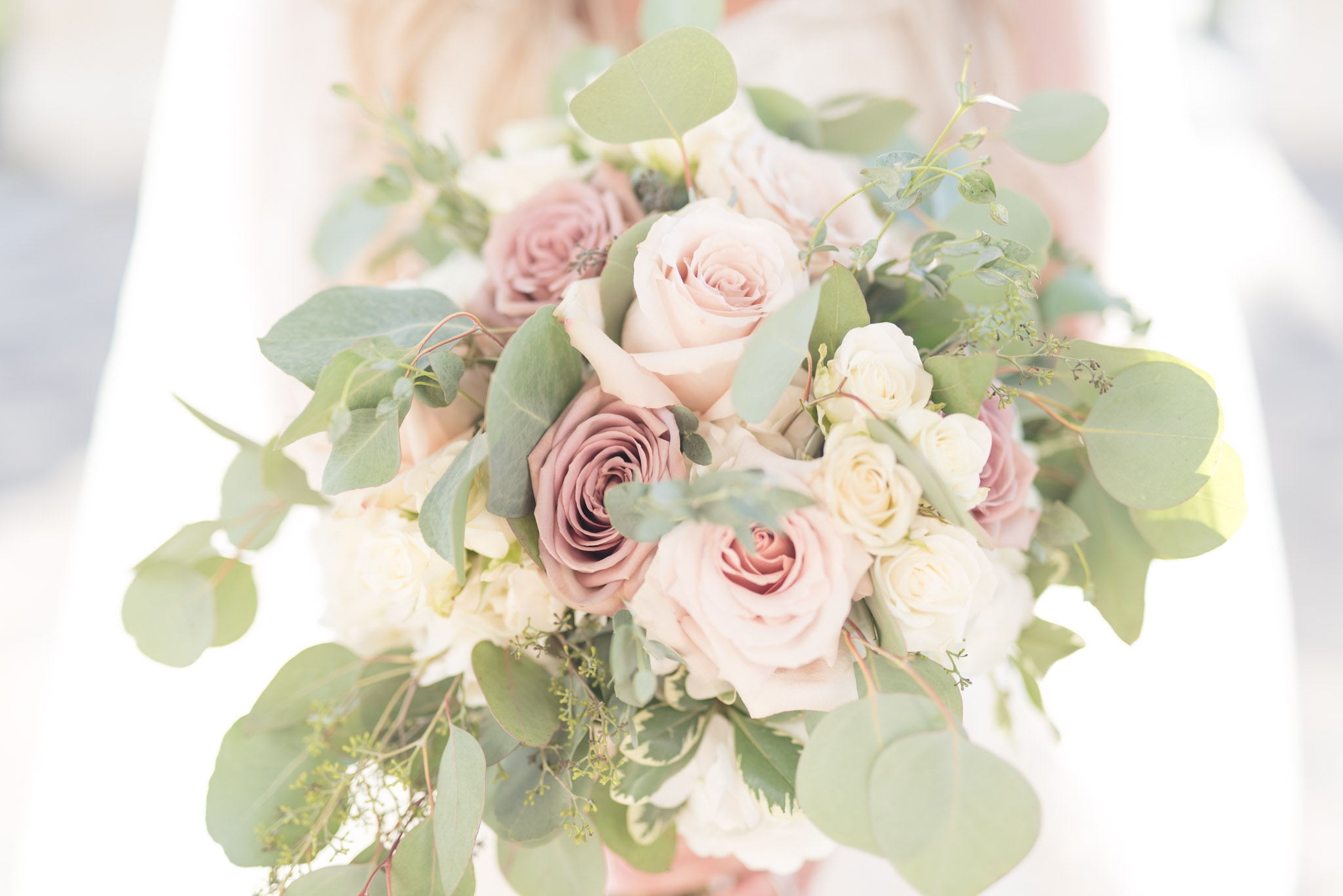 Bride holds blush bouquet.