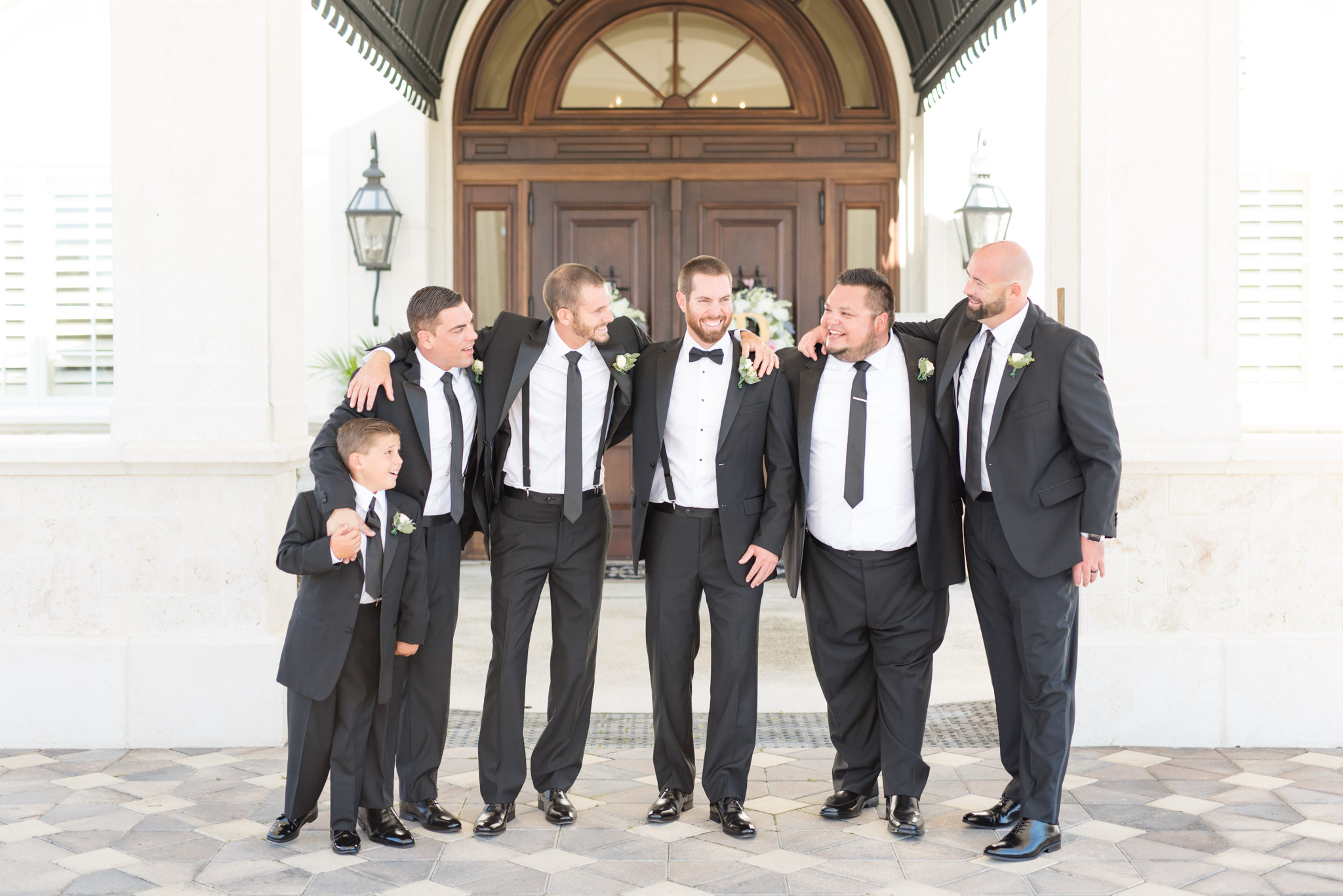 Groom and groomsmen laugh together.
