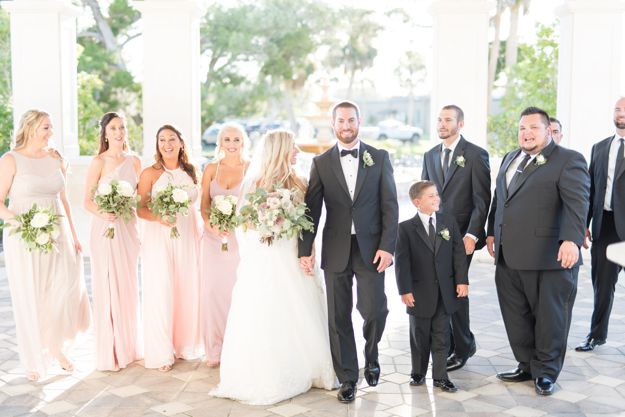 Wedding party walks together at sunset.