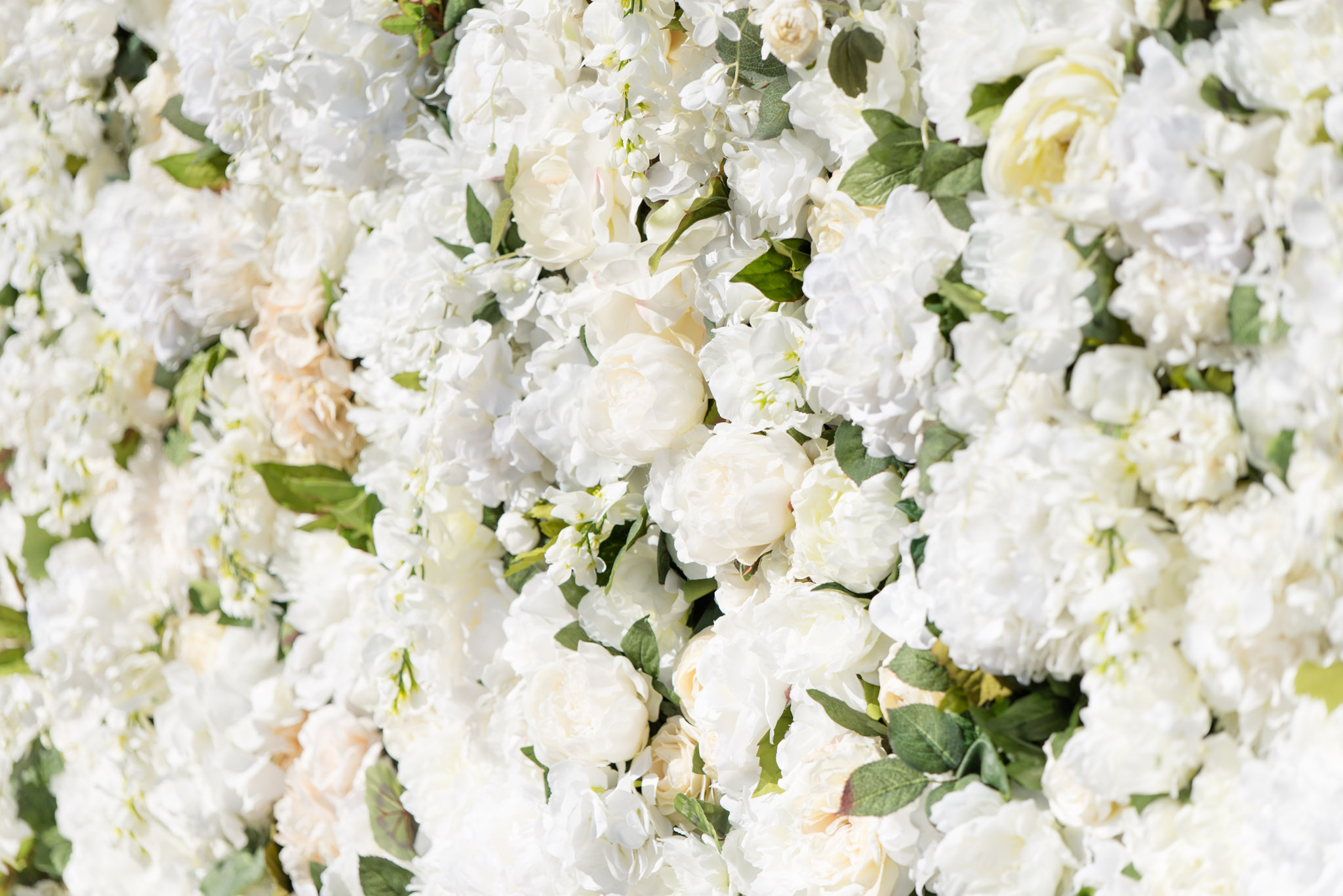 White flower wall at ceremony.