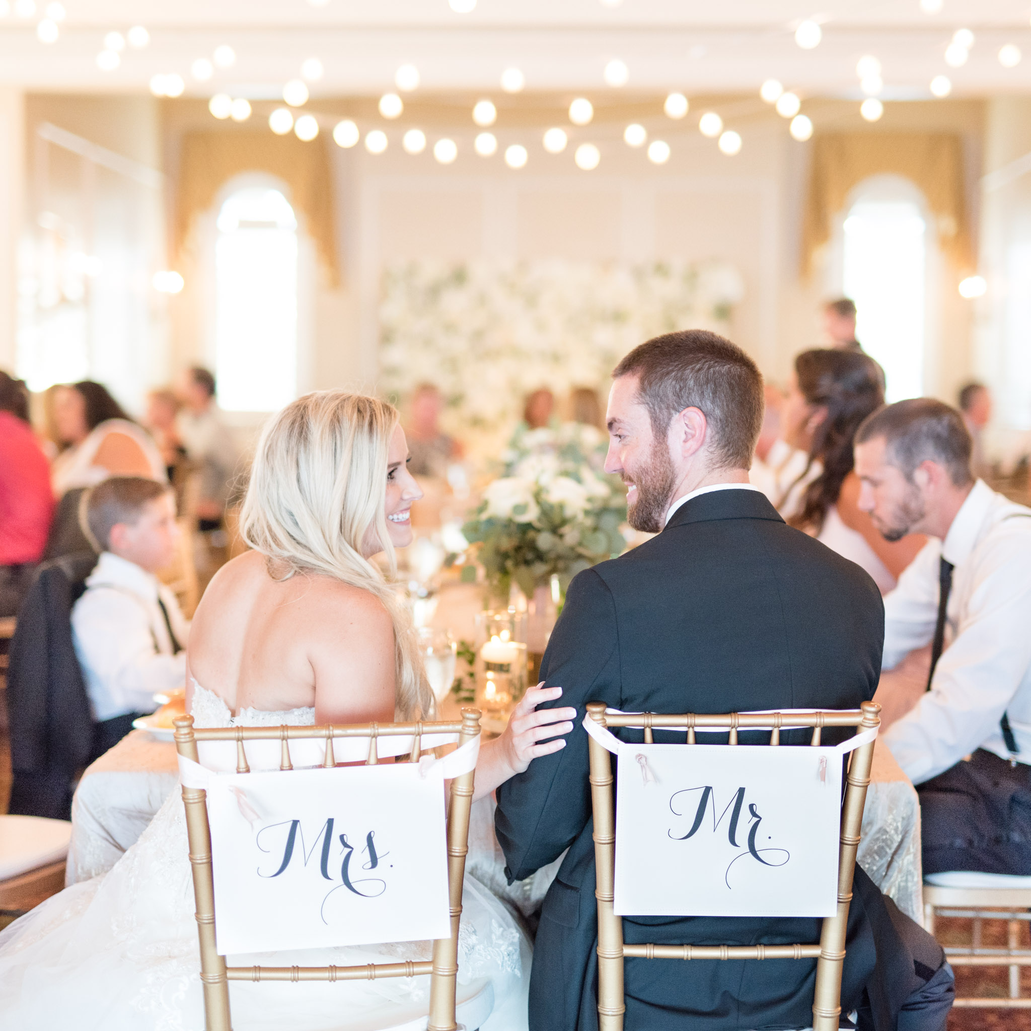 Bride and groom smile at each other during wedding reception.