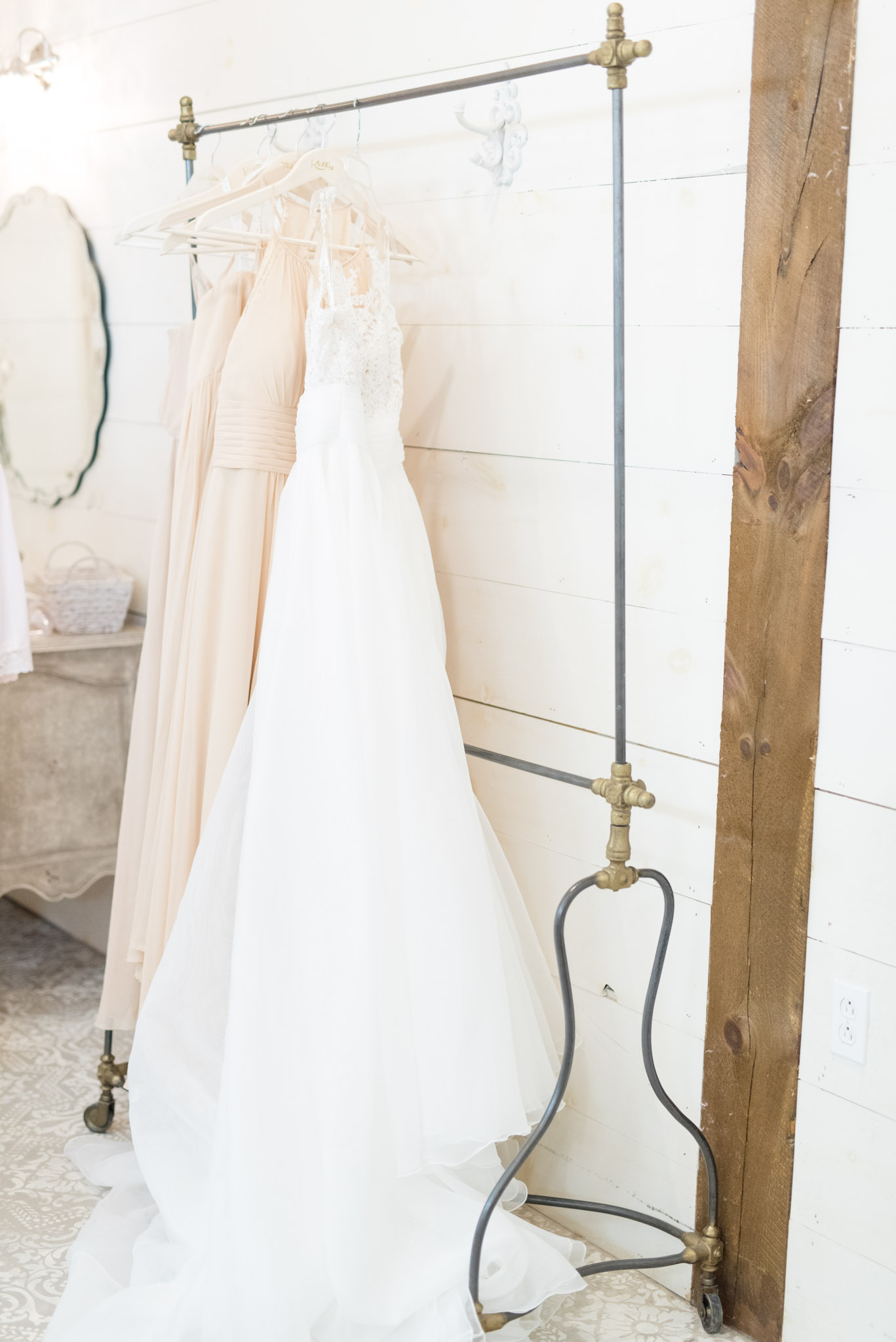 Bride and bridesmaids dresses hang together.