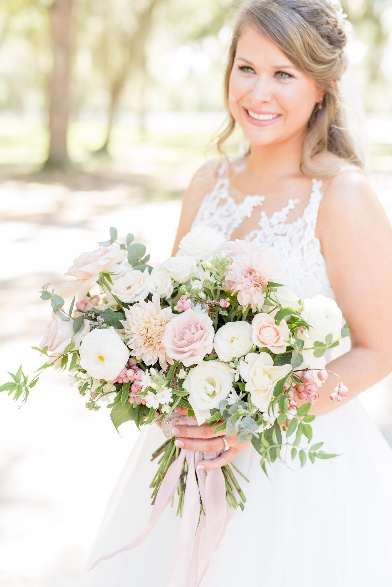 Pink and white flowers in bride's hand.