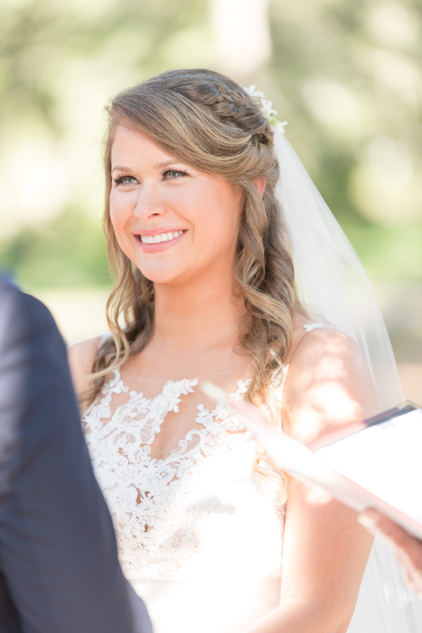 Bride smiles at groom during ceremony.