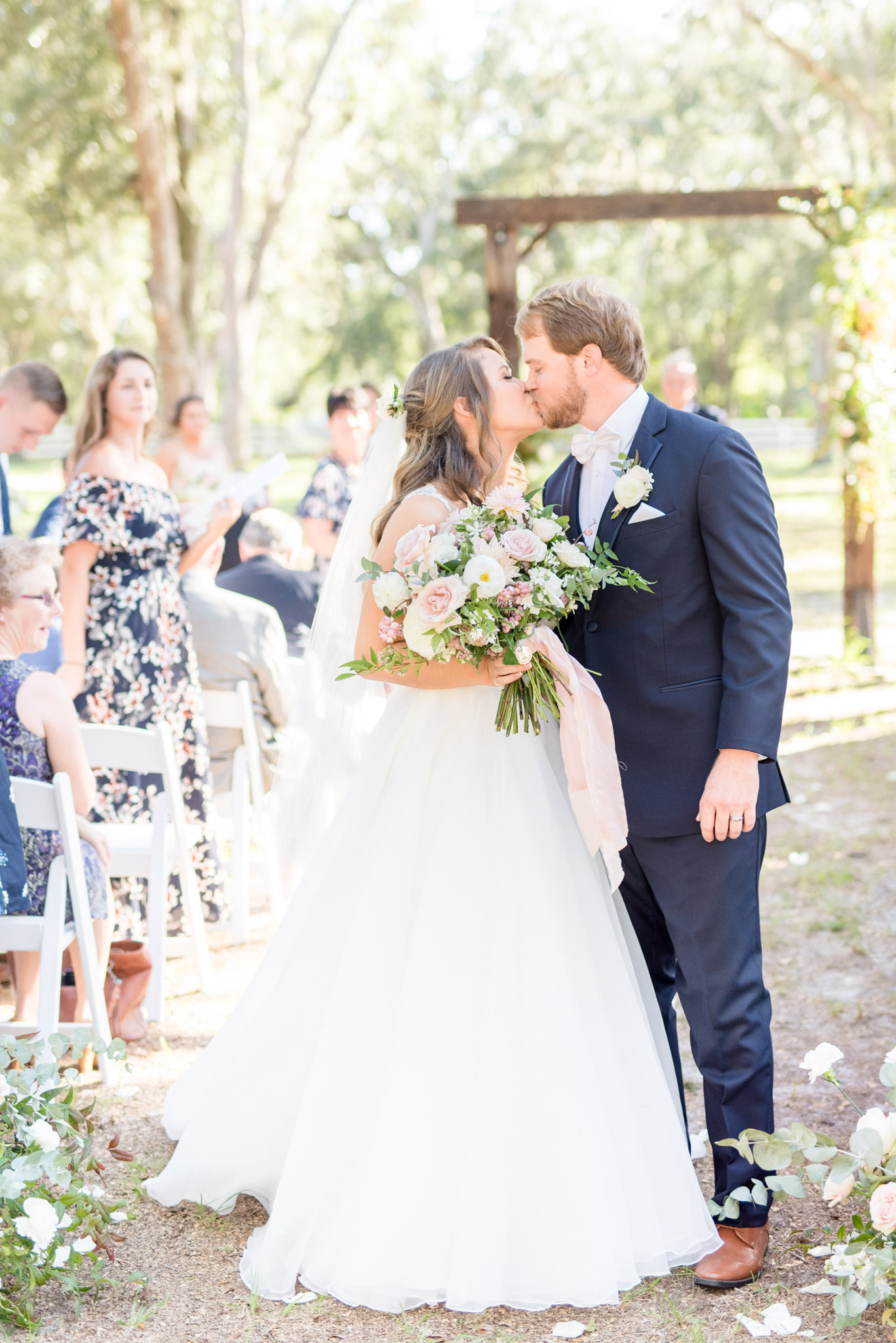 Bride and groom kiss as they walk down the aisle.