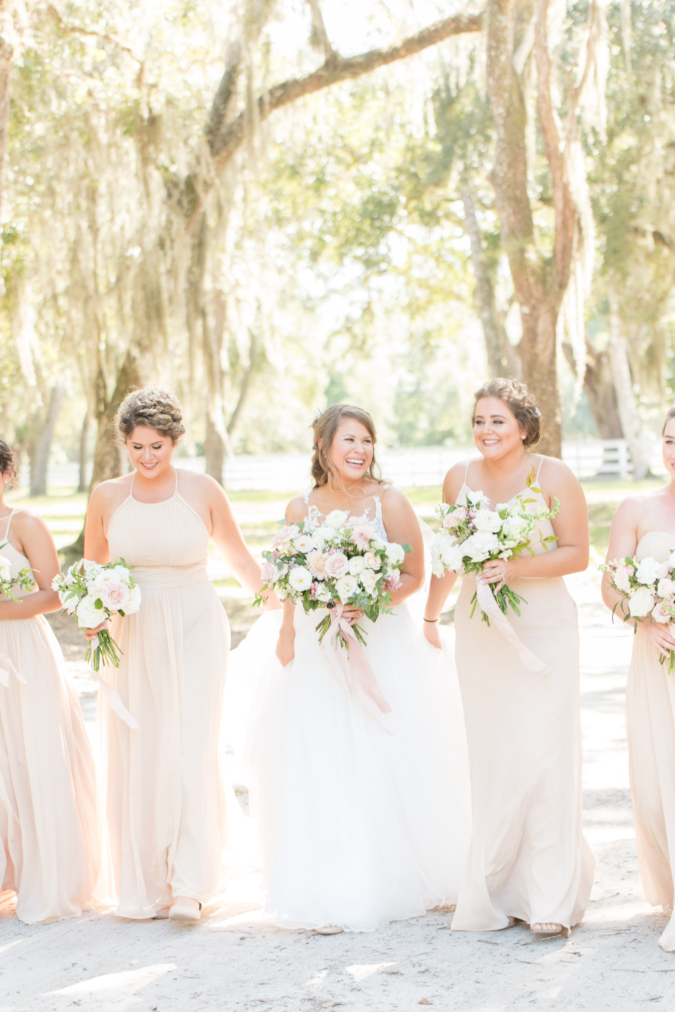 Bride laughs with bridesmaids.