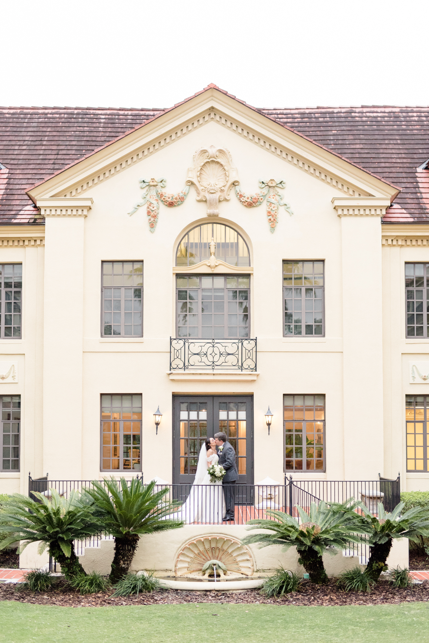 Bride and groom kiss at mansion.