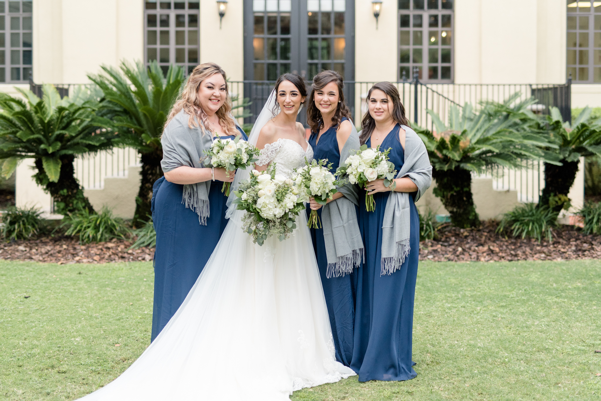 Bride and bridesmaids smile together.