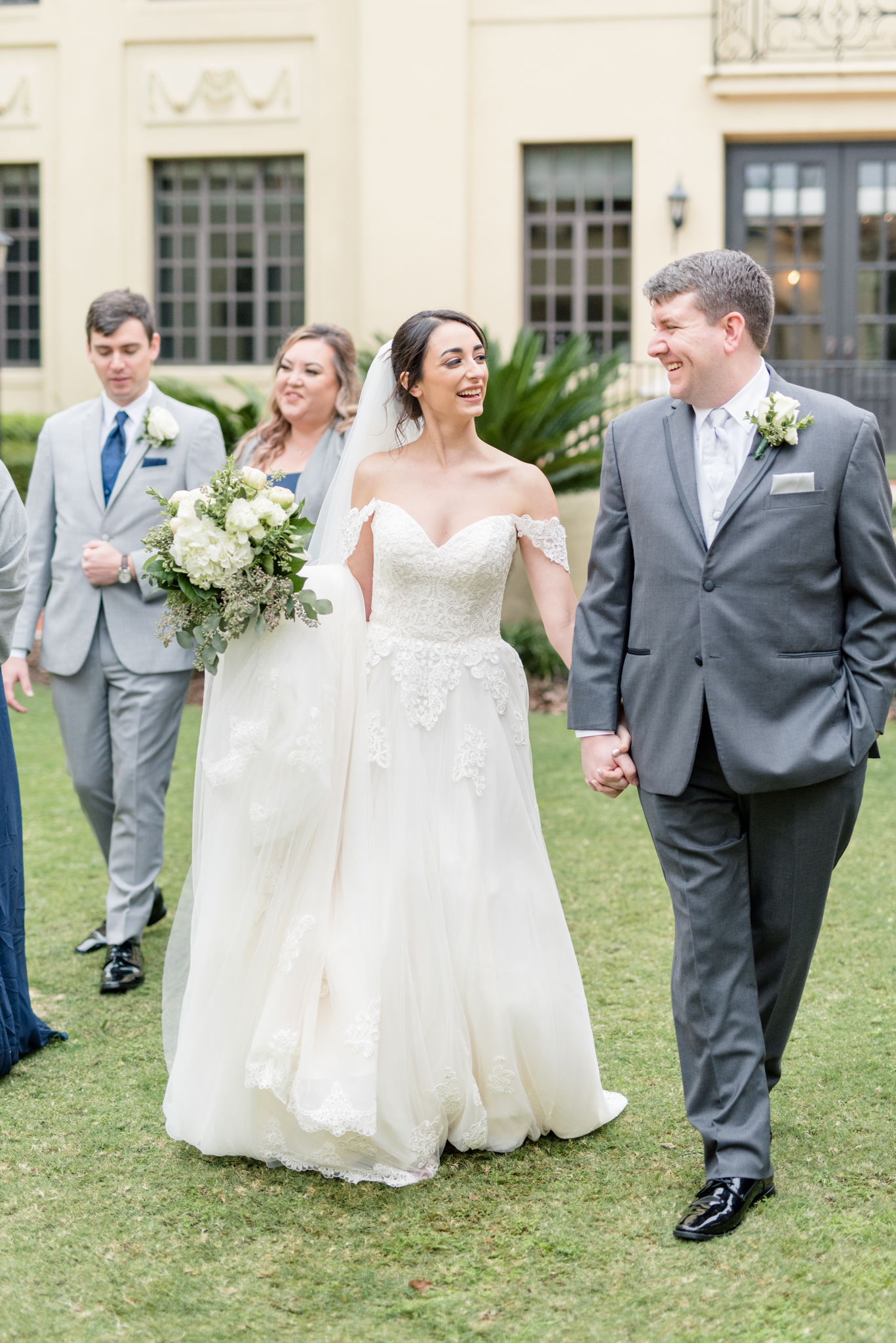 Bride and groom walks with wedding party.