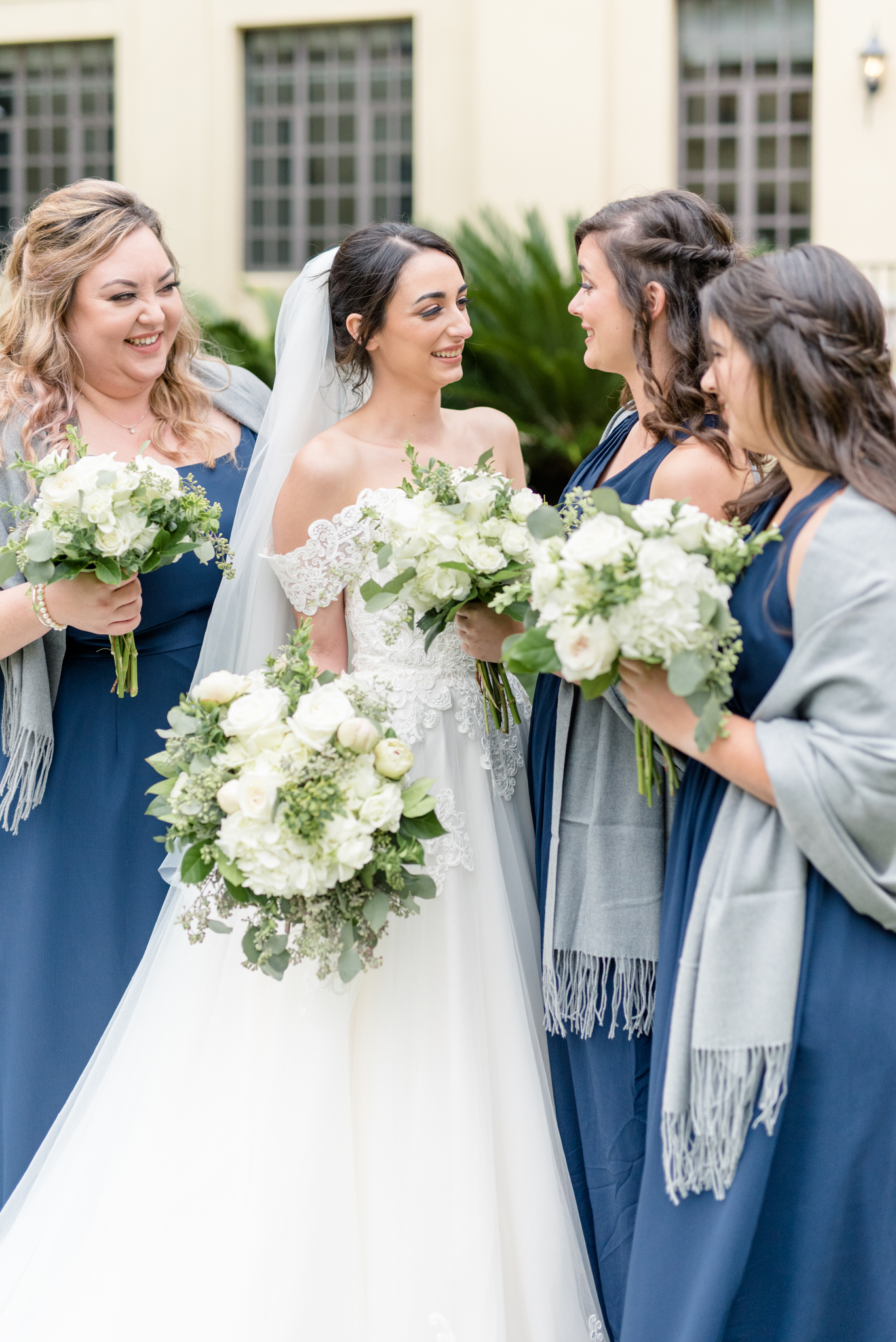 Bride and bridesmaids laugh together.