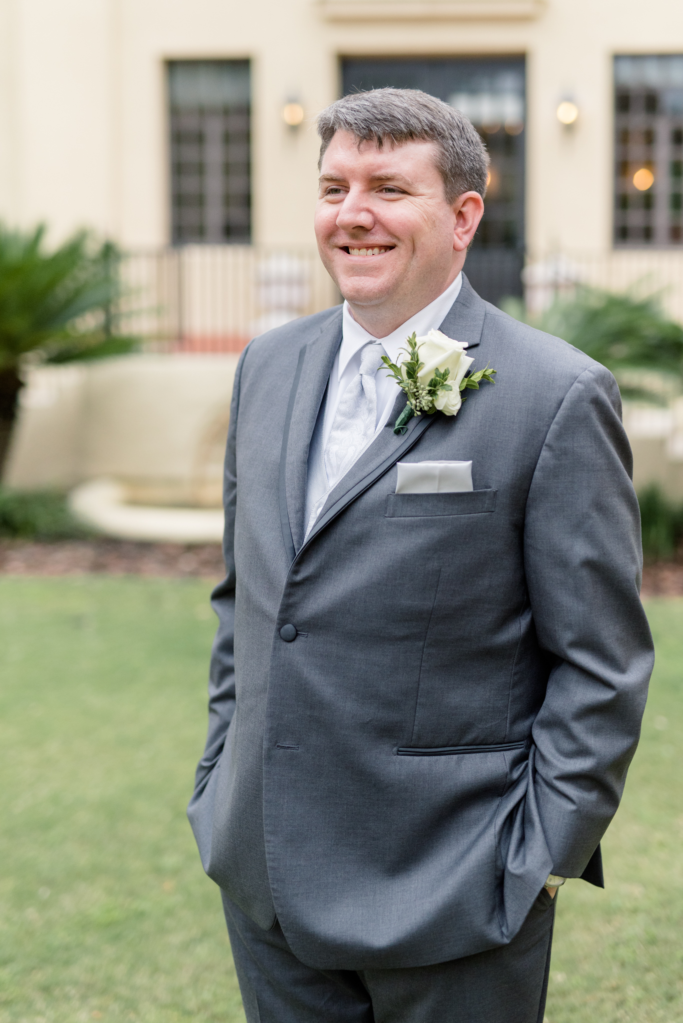 Groom smiles off camera.