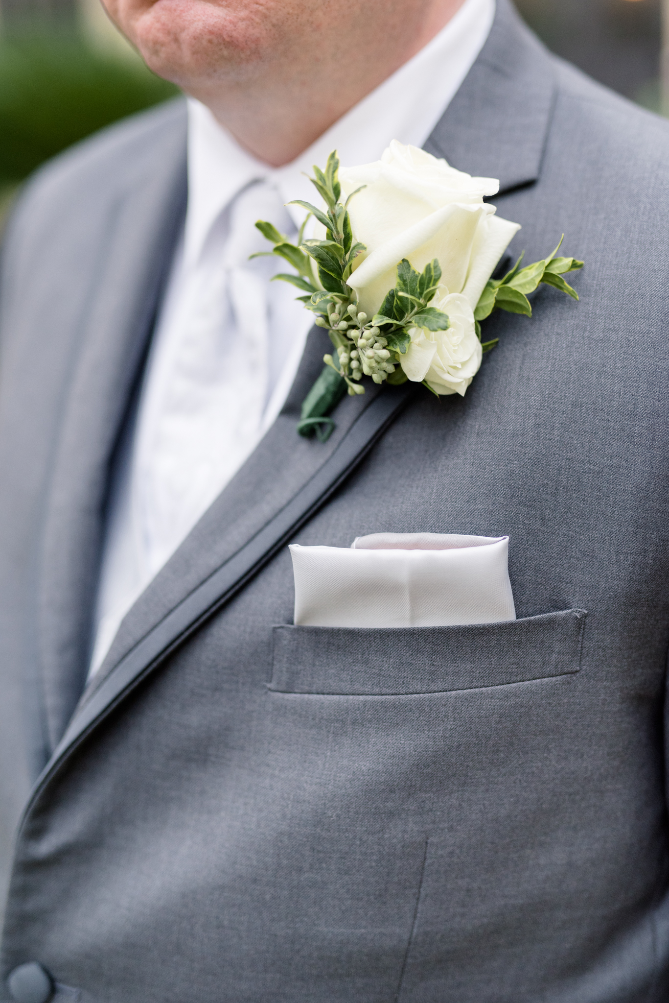Groom's boutonniere and wedding attire.