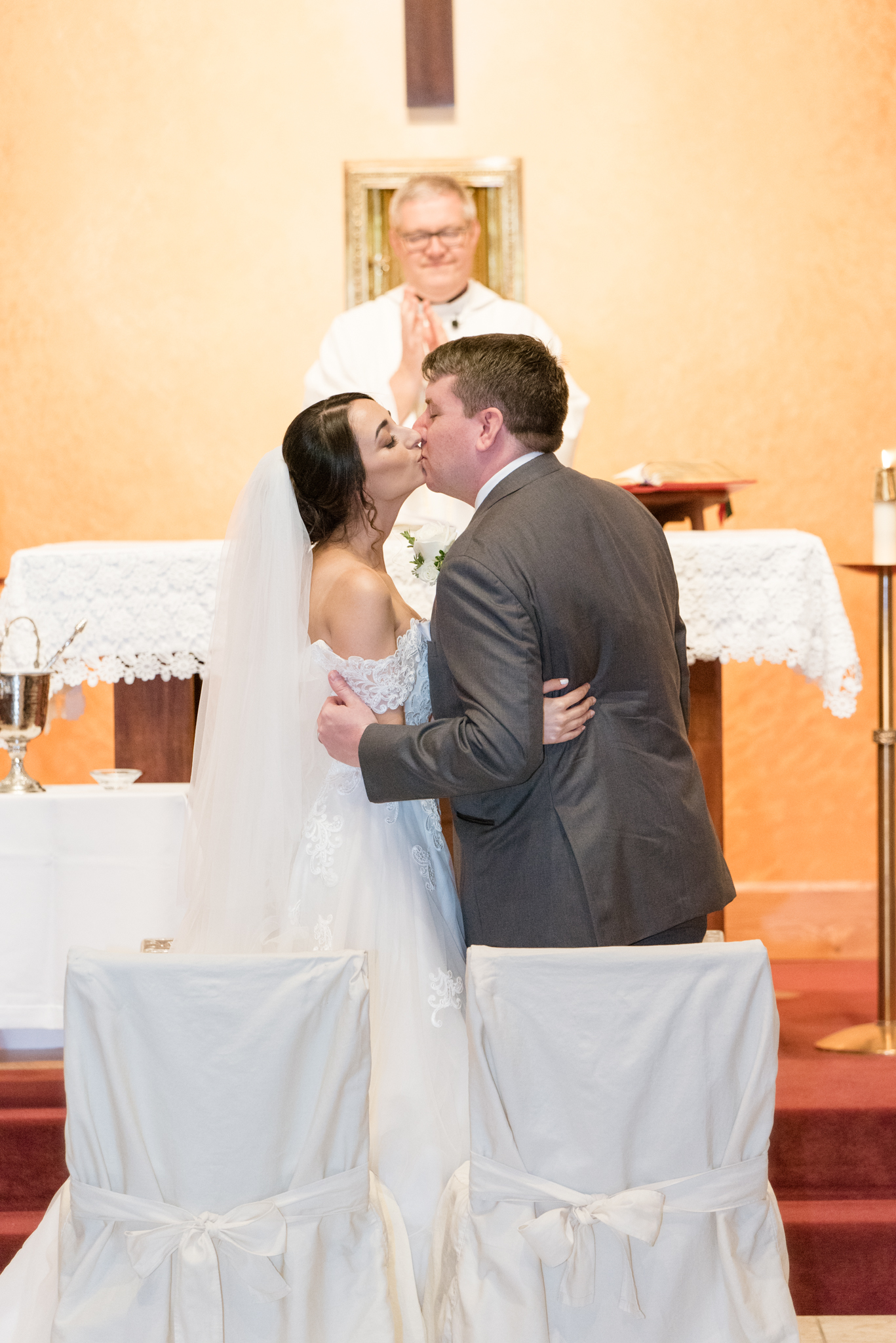 Bride and groom kiss at wedding ceremony.