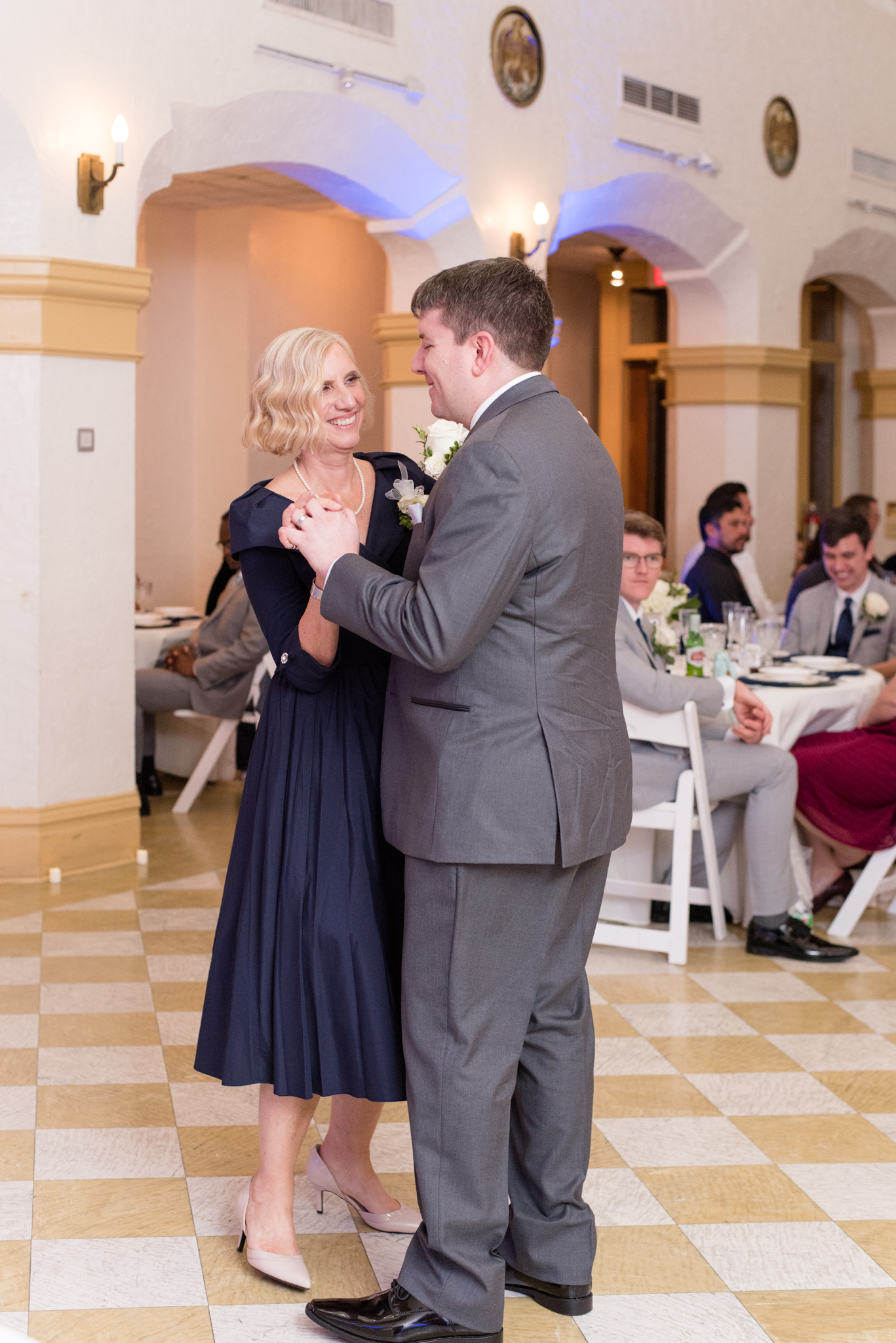 Bride and his mom dance together.