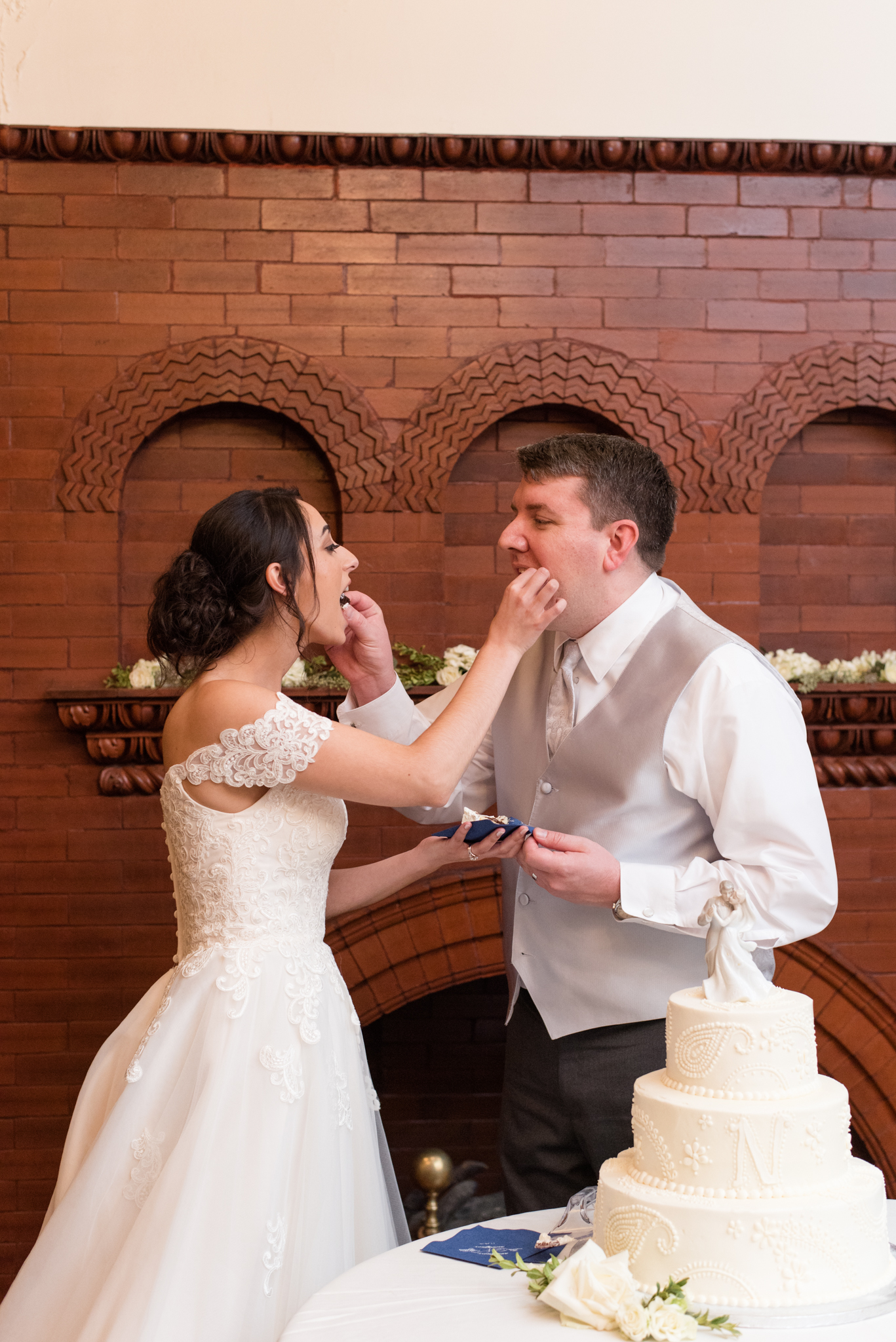 Bride and groom feed each other cake.