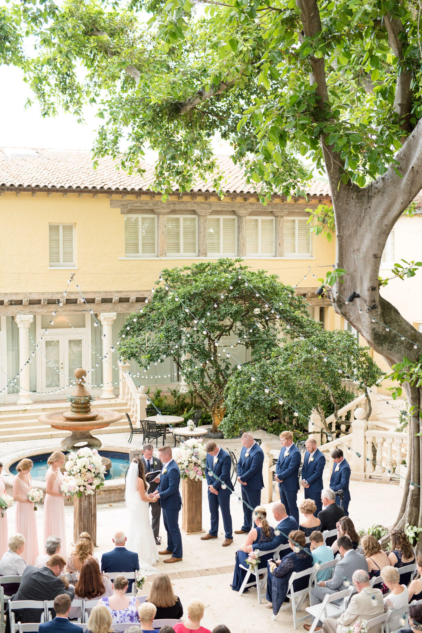 Bride and groom stand in courtyard during ceremony.