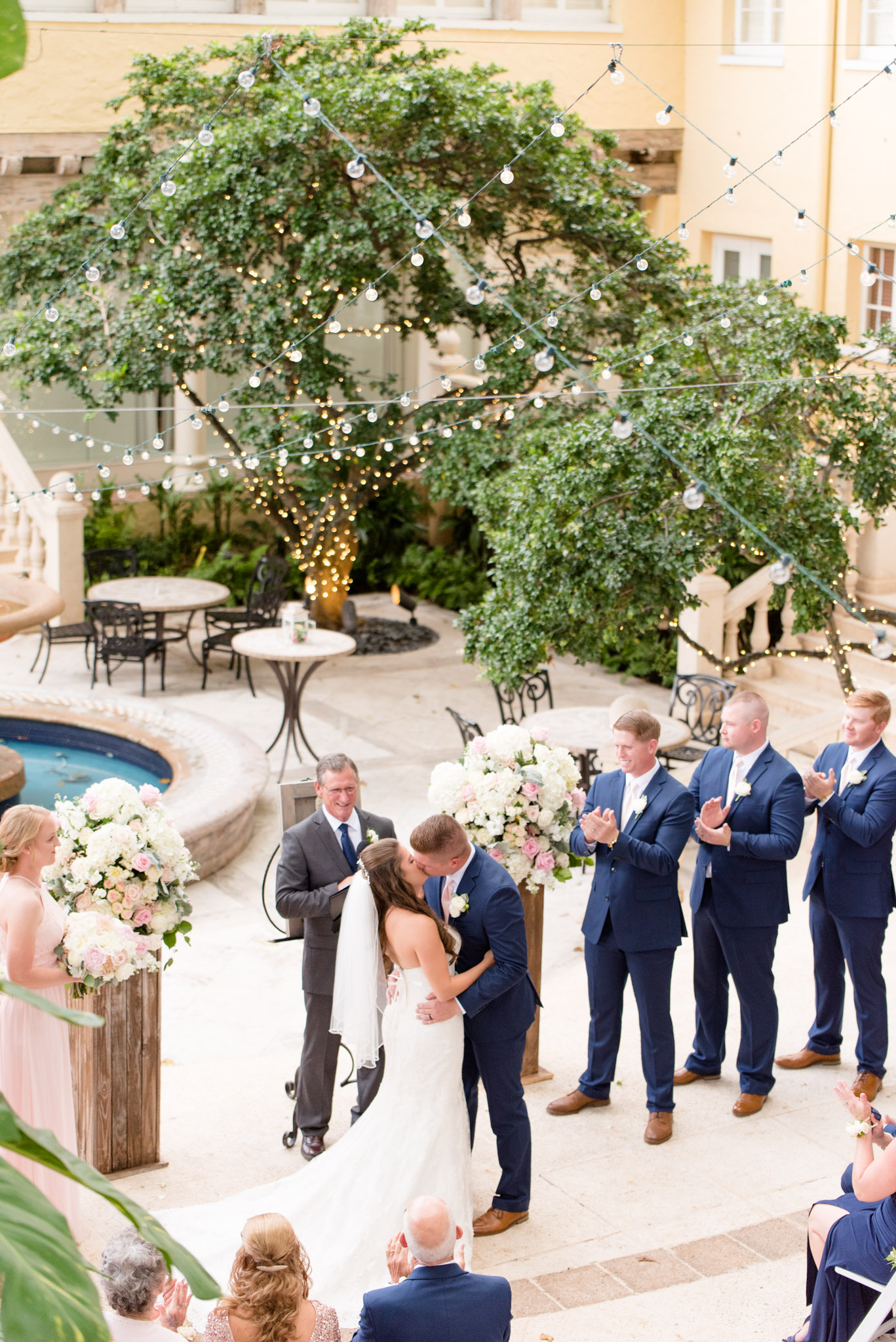 Bride and groom kiss at altar.