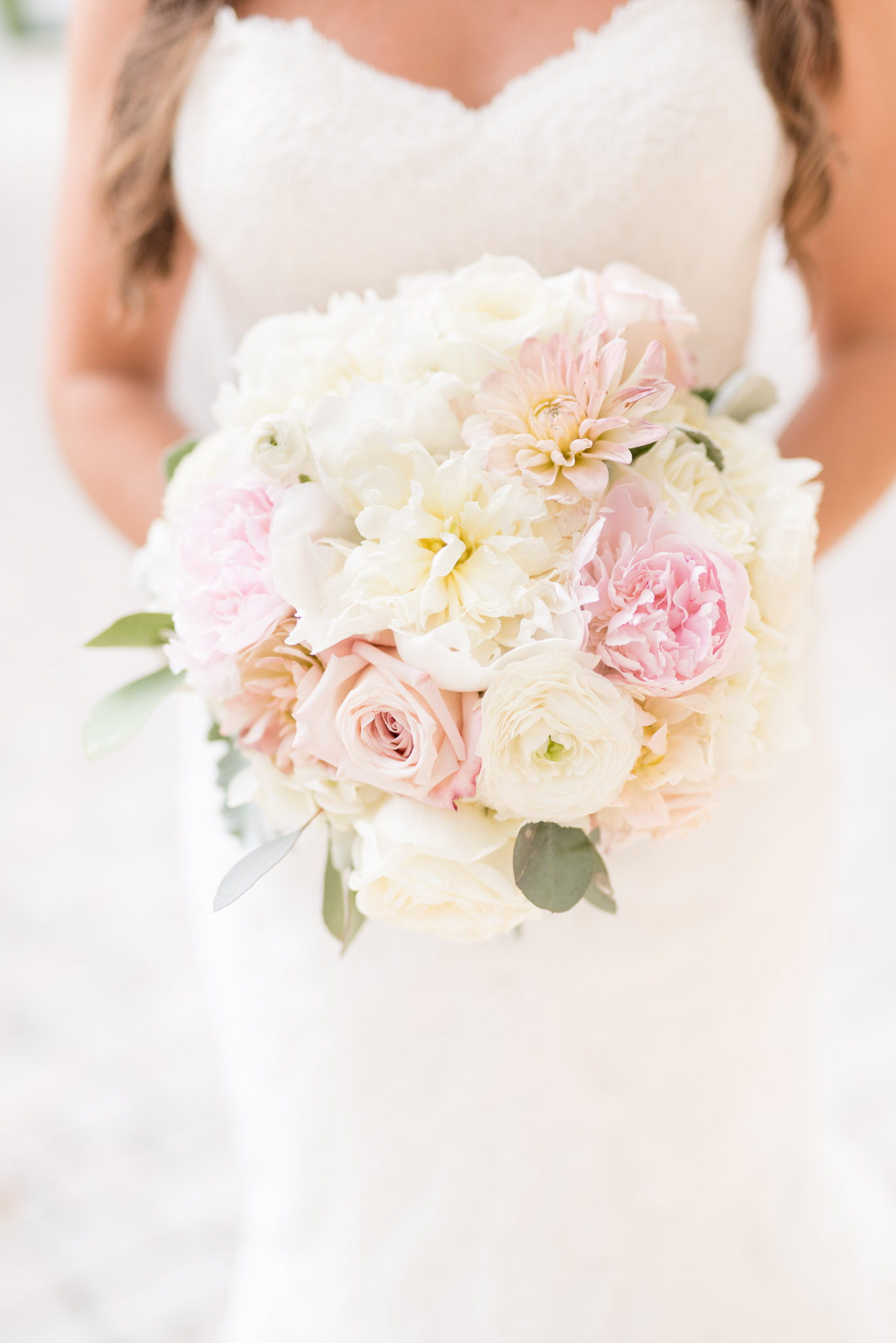 Bride holds white and pink flowers.