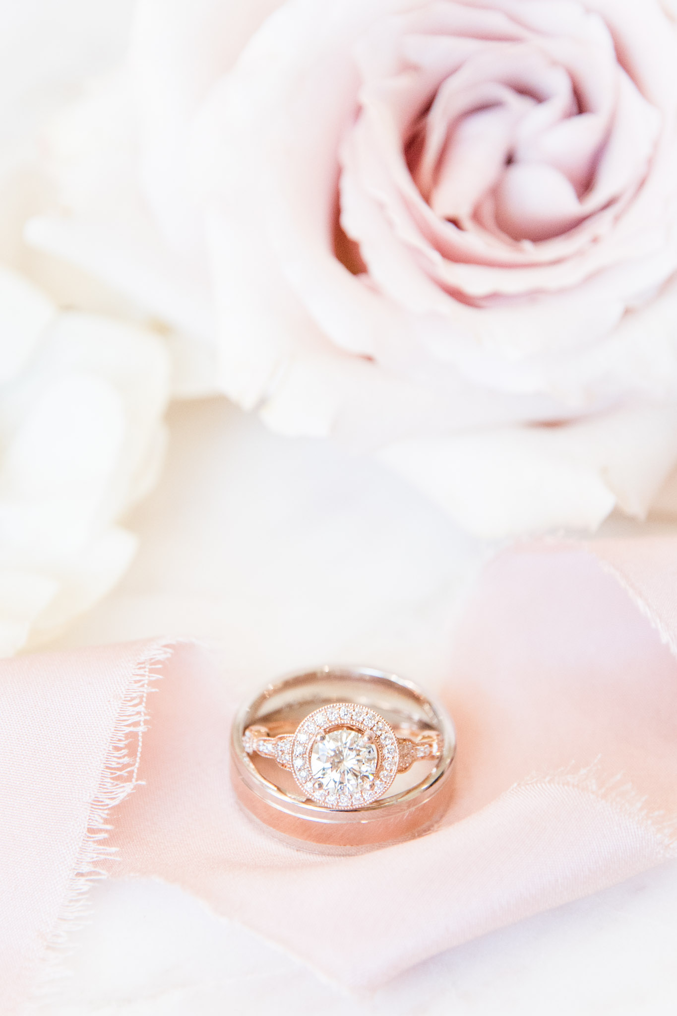 Wedding rings sit with ribbon and flowers