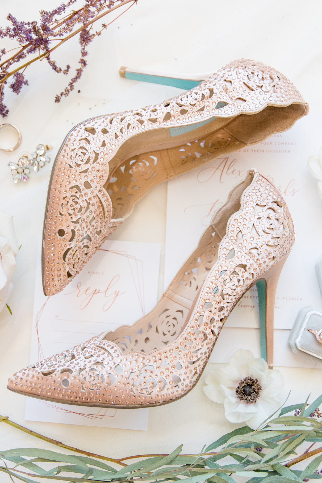 Brid'es wedding shoes sits with wedding invitations.