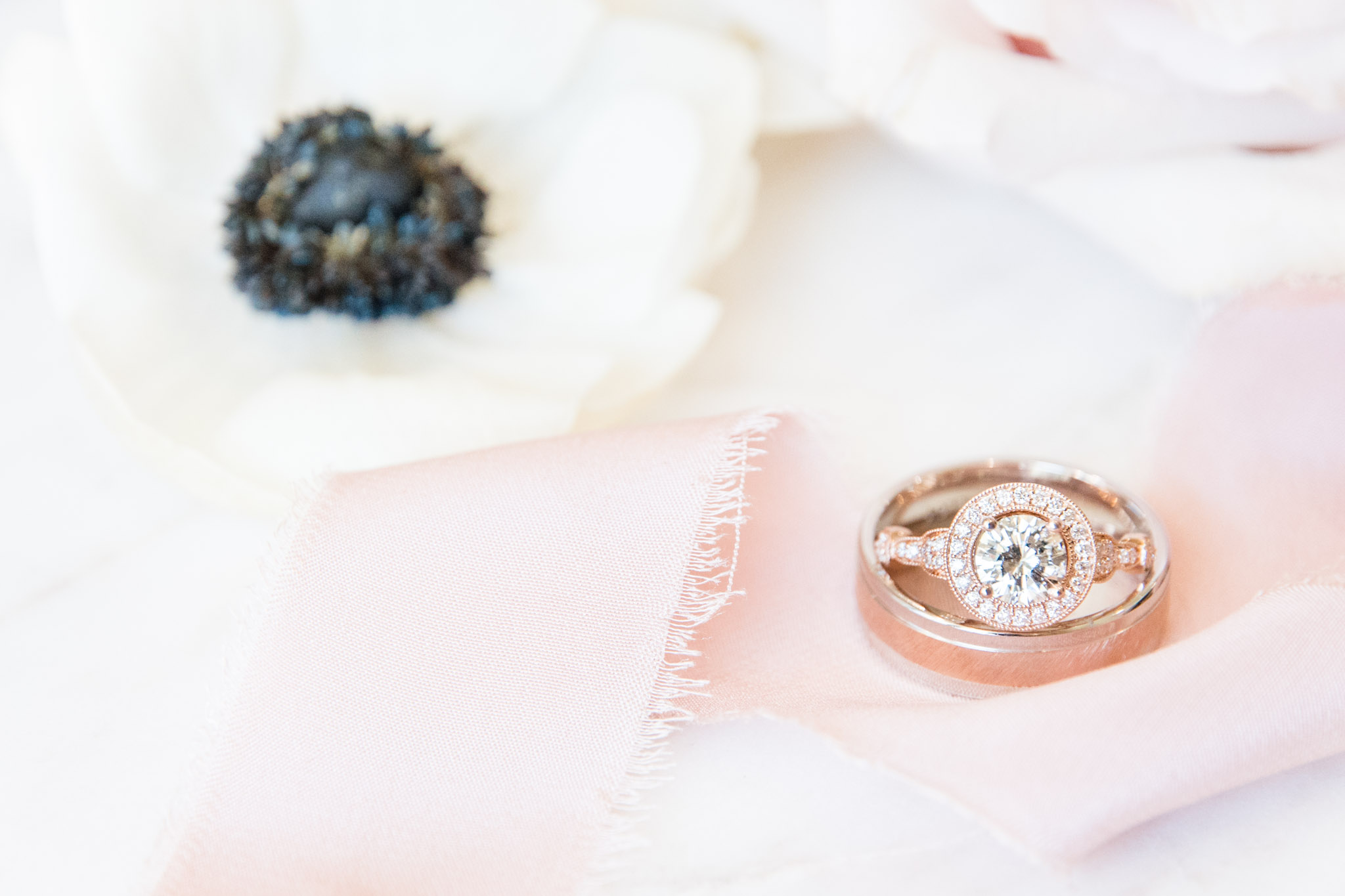 Wedding rings sit with flowers.