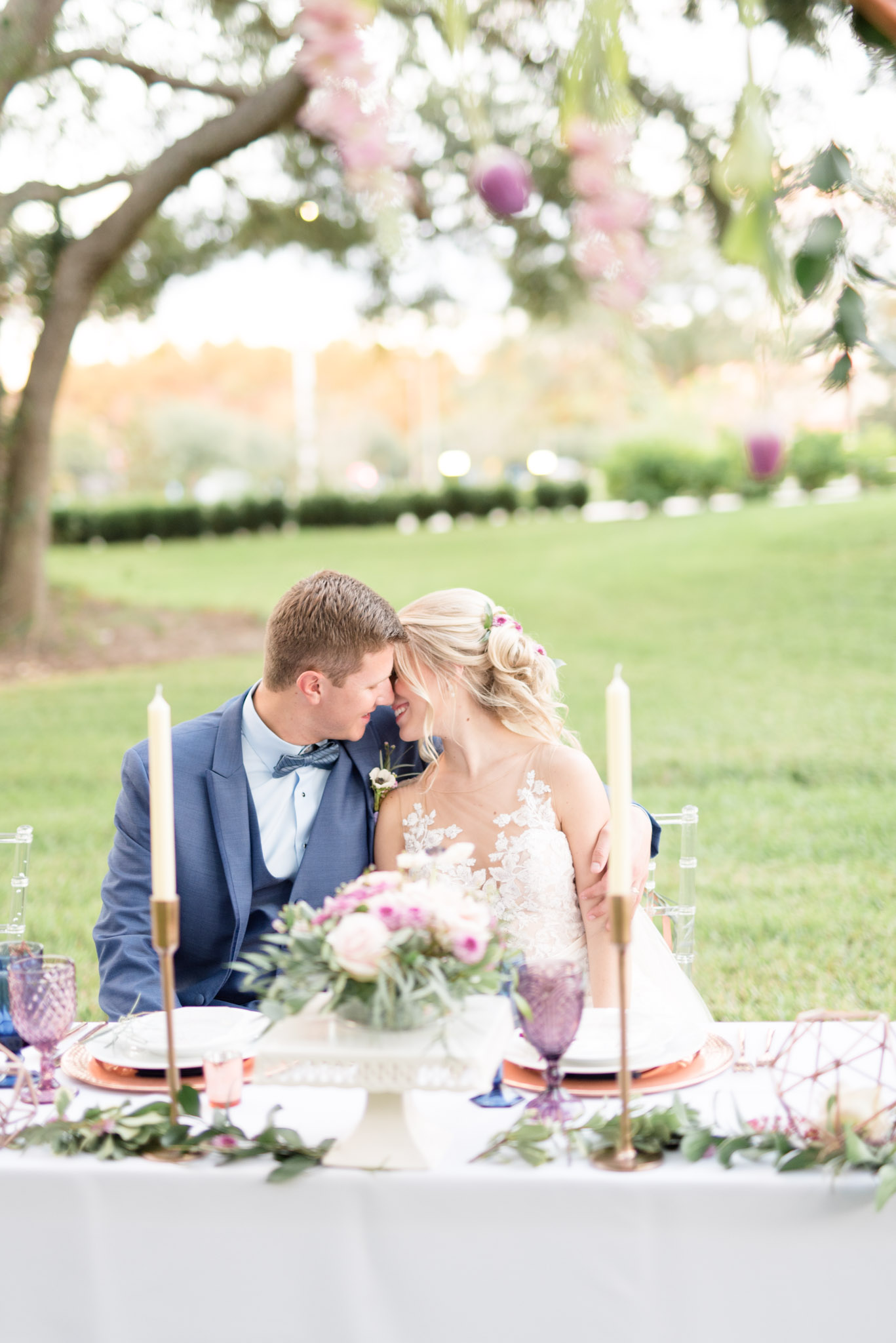 bride and groom lean in for kiss at table.